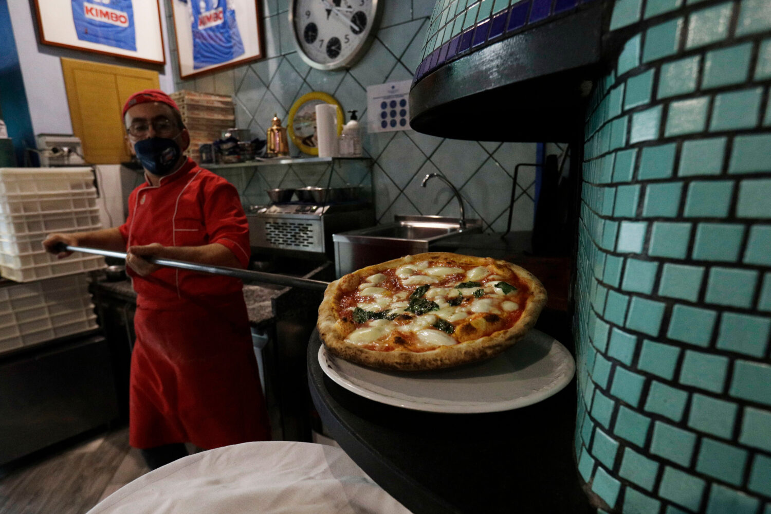 FILE -Eugenio Iorio bakes a pizza at a restaurant in Naples, Italy, Saturday, Nov. 14, 2020. (AP Ph...