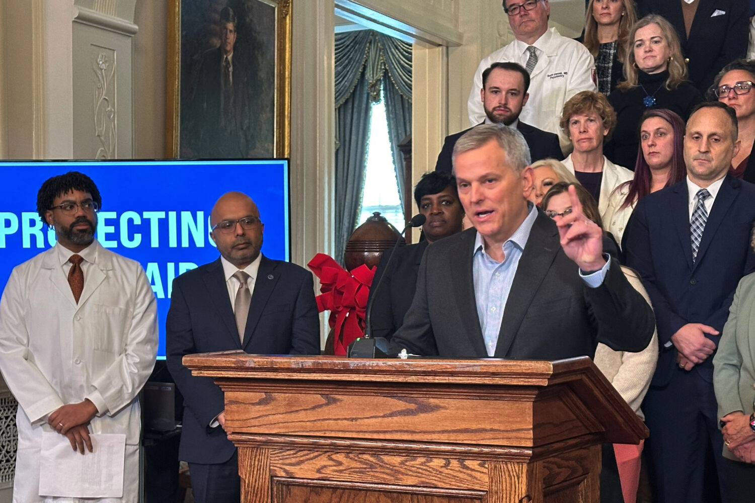 North Carolina Gov. Josh Stein, right, speaks while Dr. Benjamin Simmons with the North Carolina Ac...