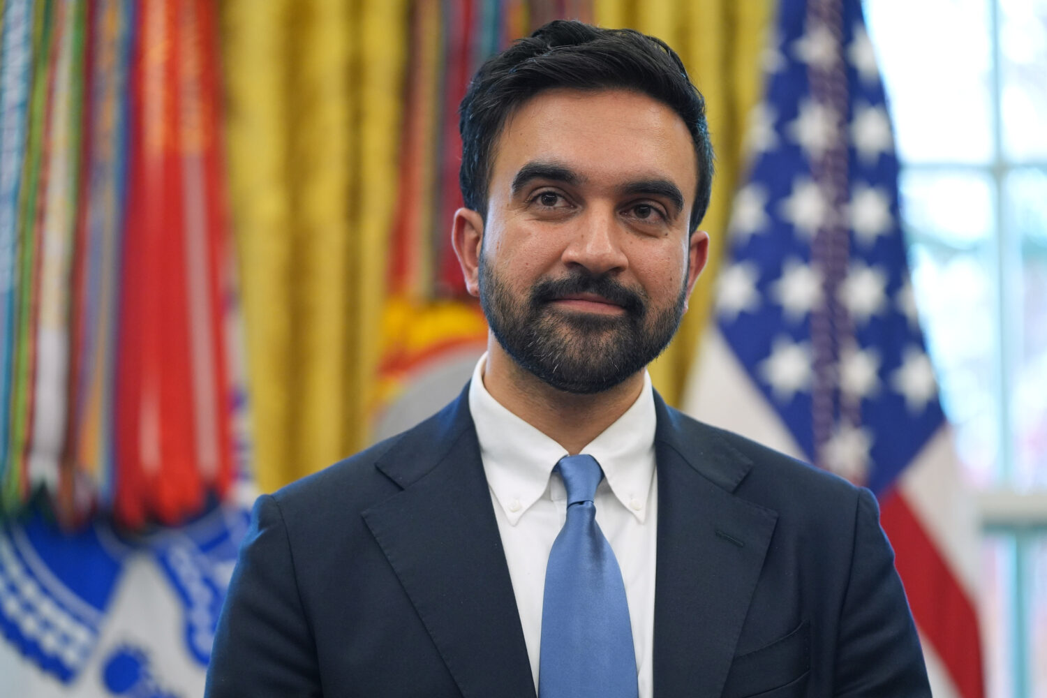 FILE - New York City Mayor-elect Zohran Mamdani listens as President Donald Trump speaks in the Ova...
