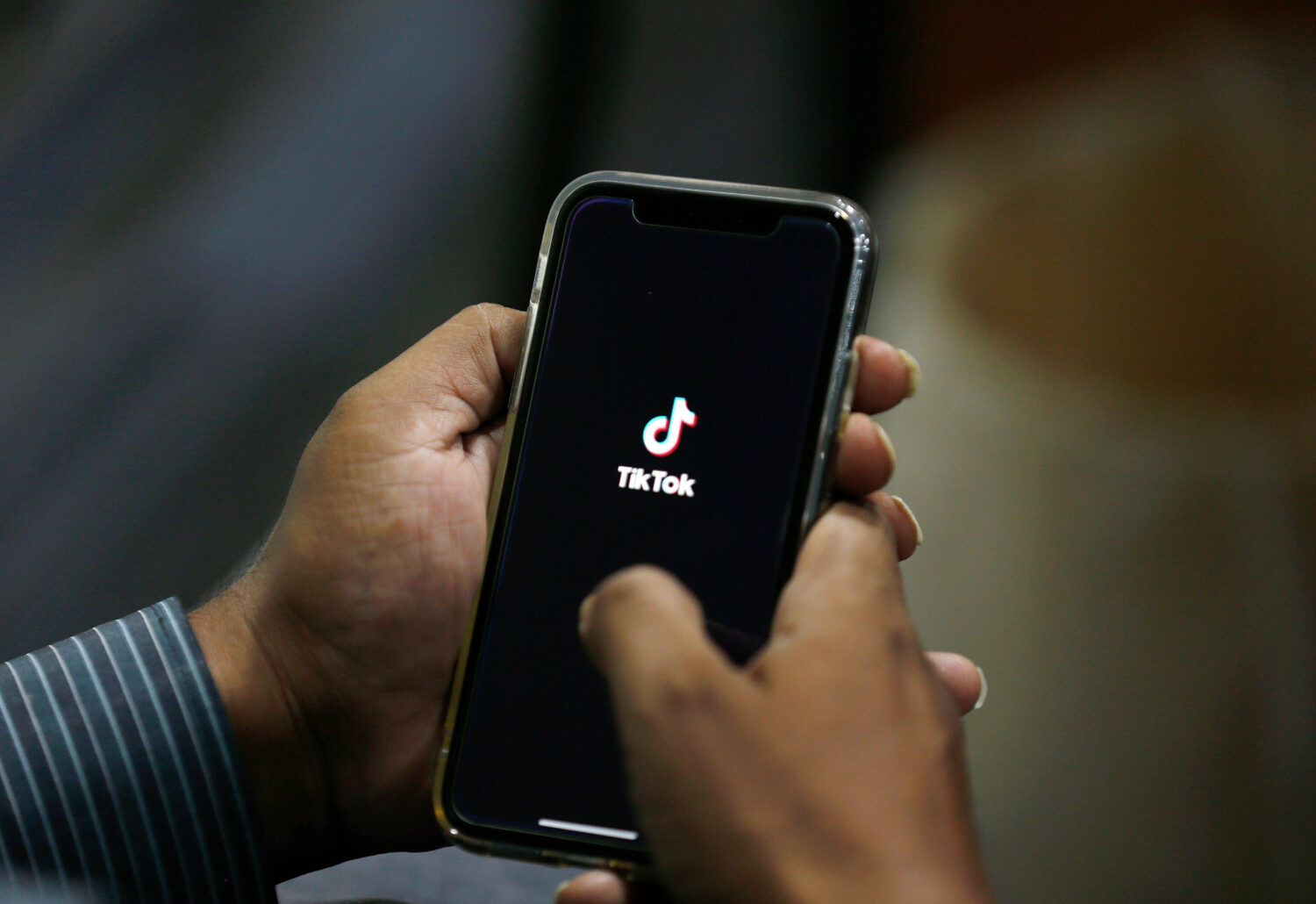 FILE - In this July 21, 2020 file photo, a man opens social media app 'TikTok' on his cell phone, i...