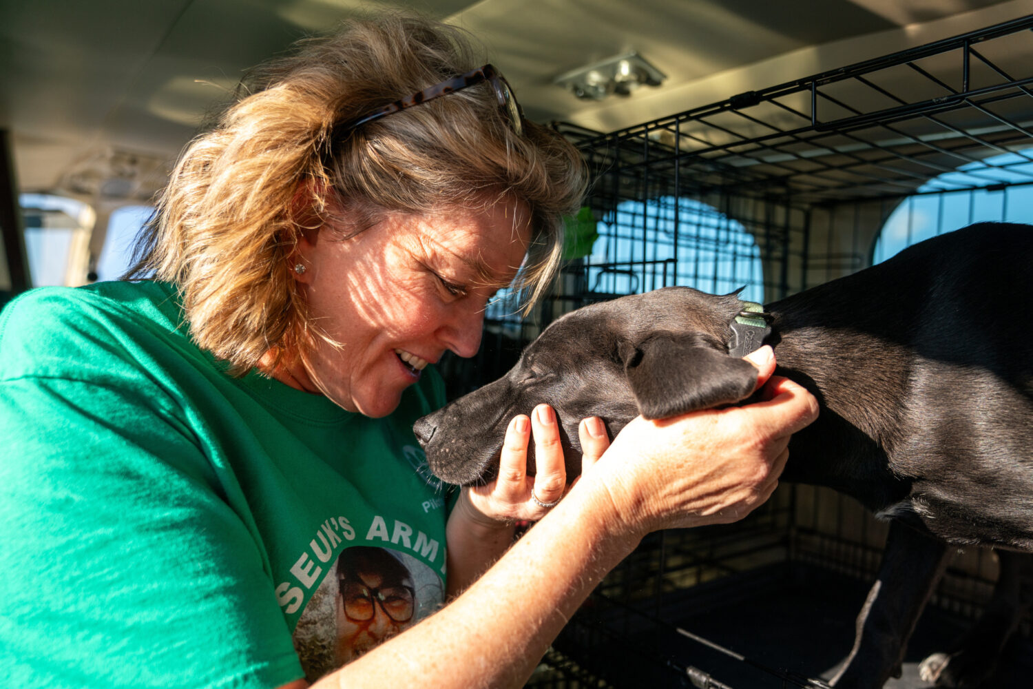 Sydney Galley pets a dog on a plane before passing it off to other volunteers, Nov. 23, 2025, at Cu...