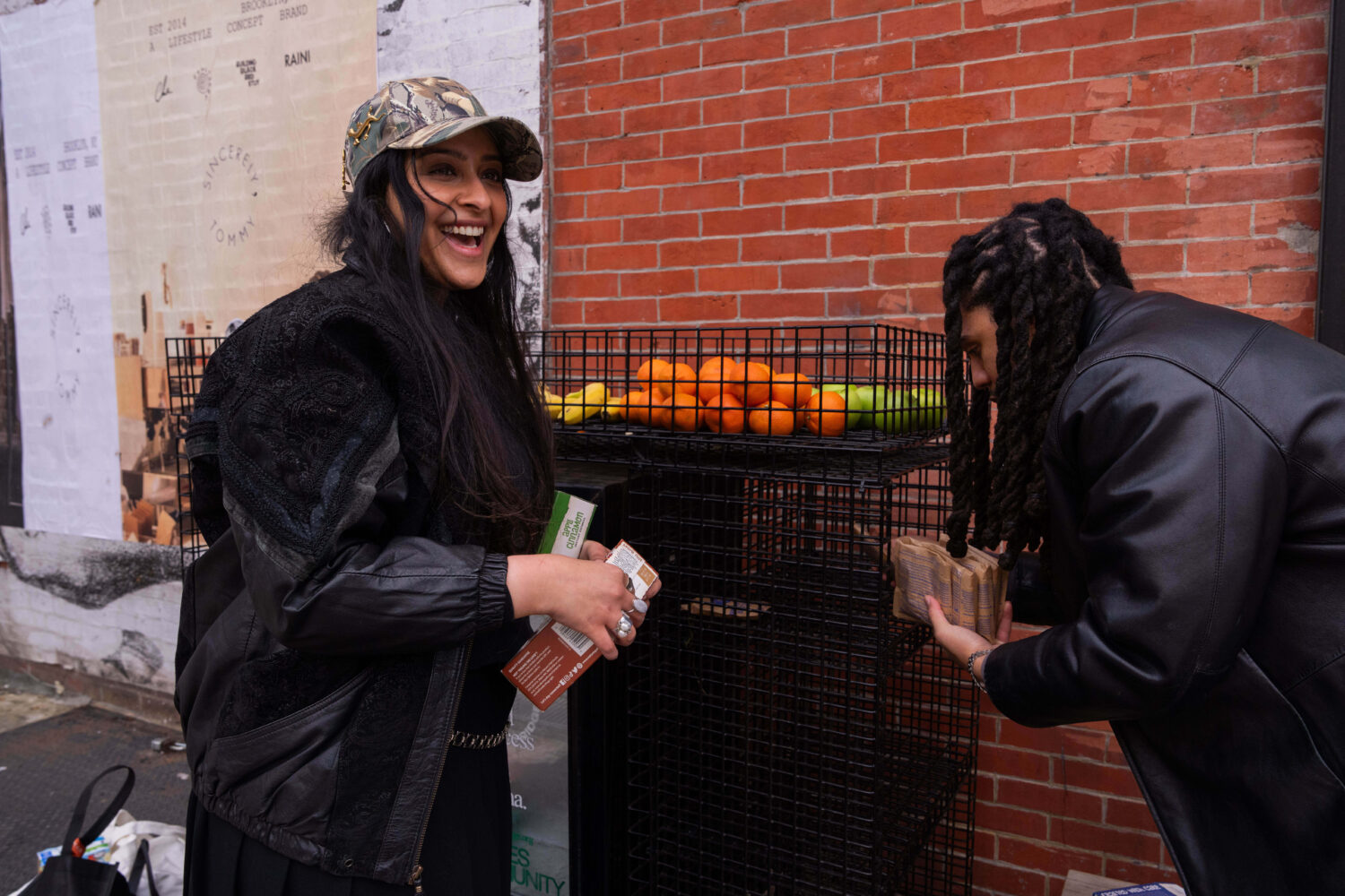Kashish Ali and Elliott McKnight stock a One Love Community Fridge with food, Nov. 15, 2025, in Bro...