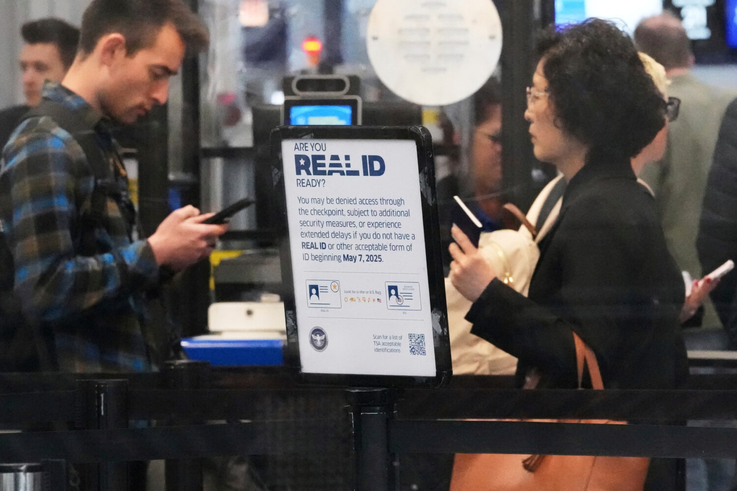 FILE - A Real ID sign is displayed as Travelers wait to go through security check point at O'Hare I...