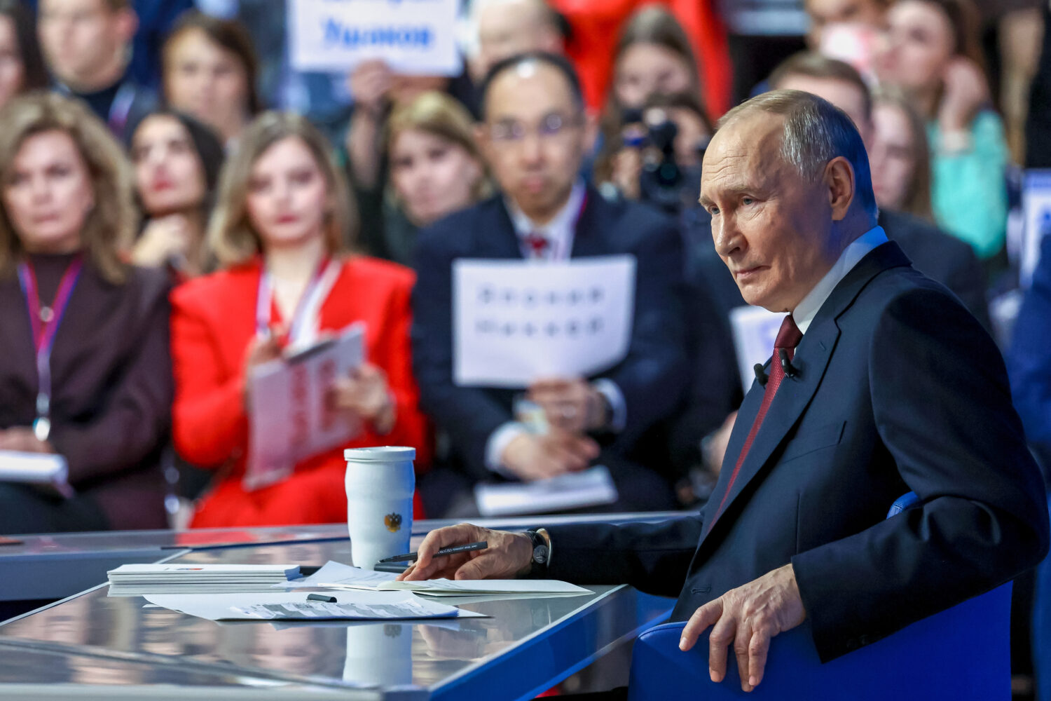Russian President Vladimir Putin listens to a journalist's question during his annual news conferen...