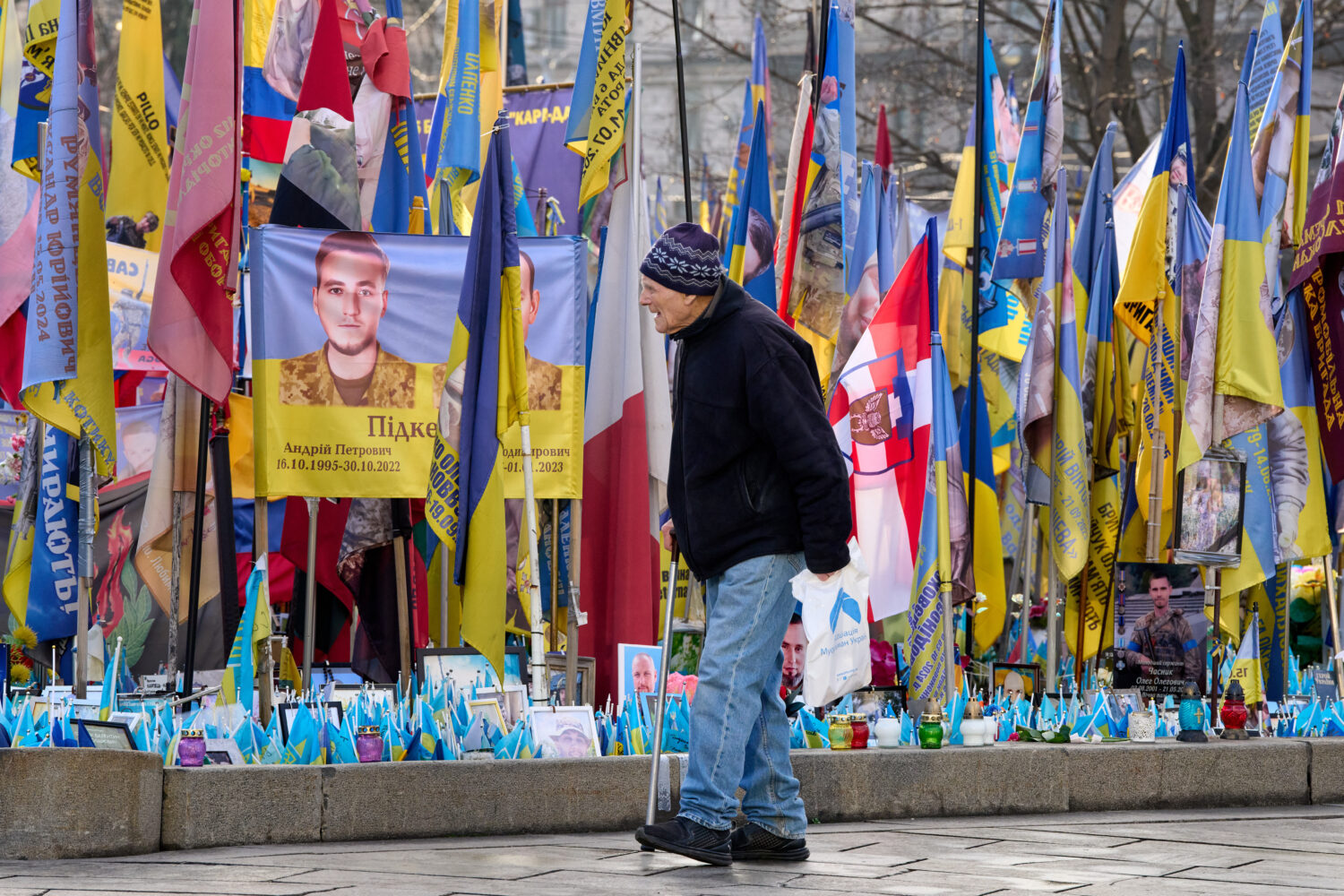 A man walks around an improvised memorial to fallen soldiers killed in the Russia-Ukraine war at In...