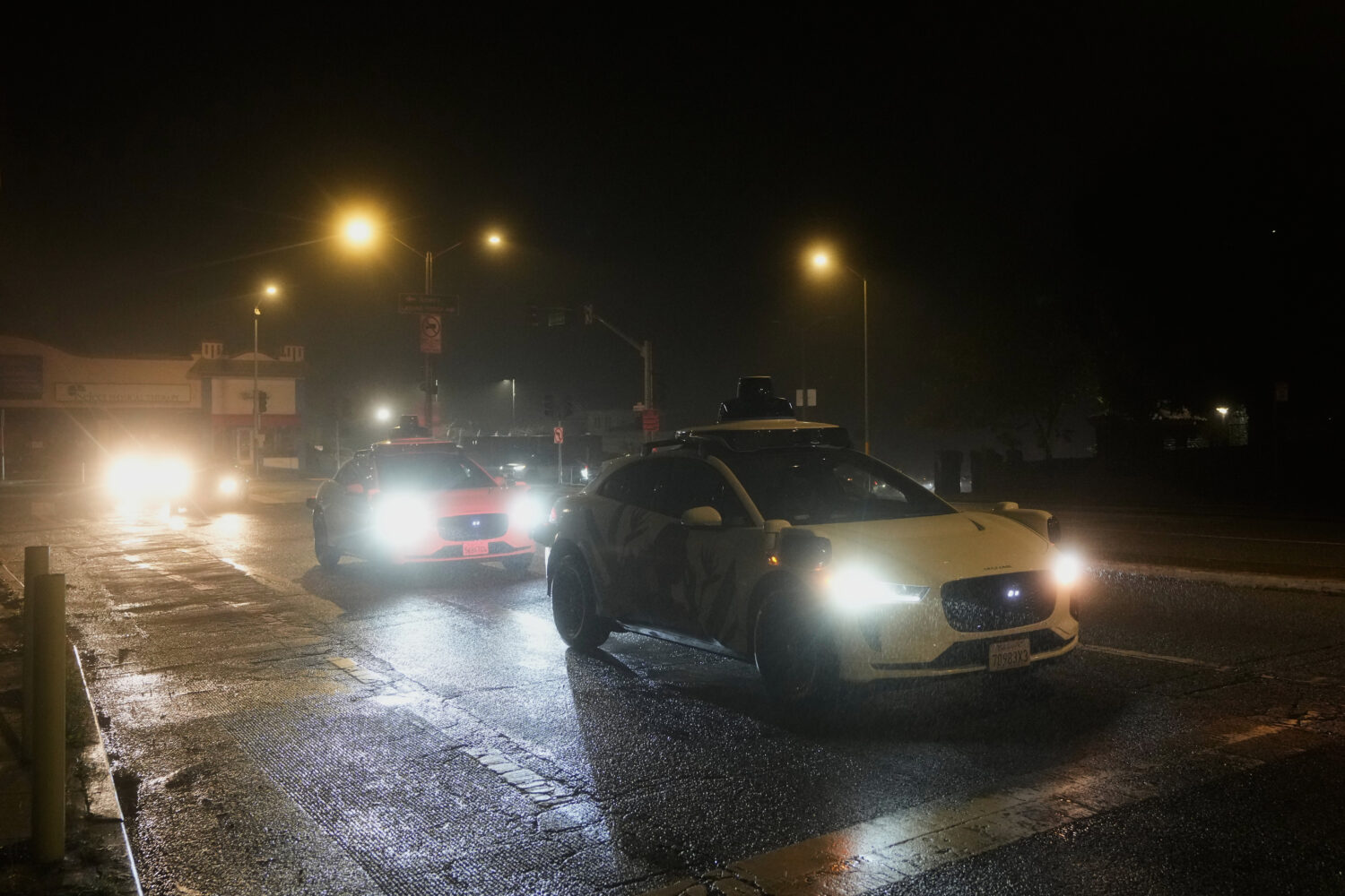 A Waymo vehicle sits idling at an intersection with no operating traffic lights due to power outage...