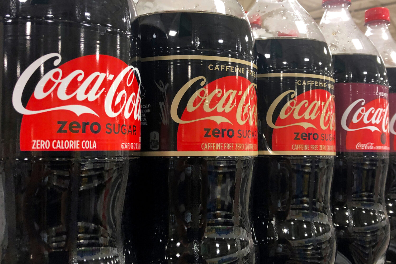 FILE - Bottles of Coca-Cola products sit on a shelf at a store in Dania Beach, Fla., Oct. 20, 2020....