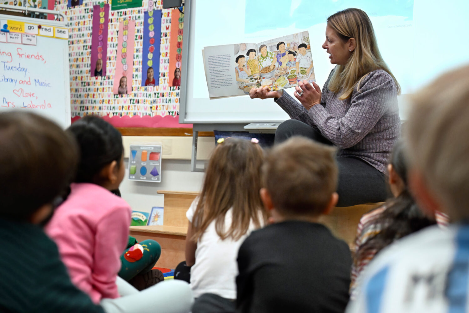 Kindergarten teacher Christin Labriola reads the book "Dumpling Soup" to her class, incorporating A...