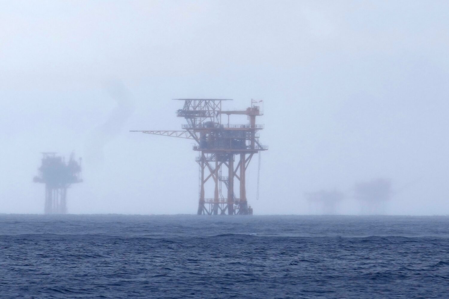 FILE - Oil platforms are visible through the haze near the Flower Garden Banks National Marine Sanc...