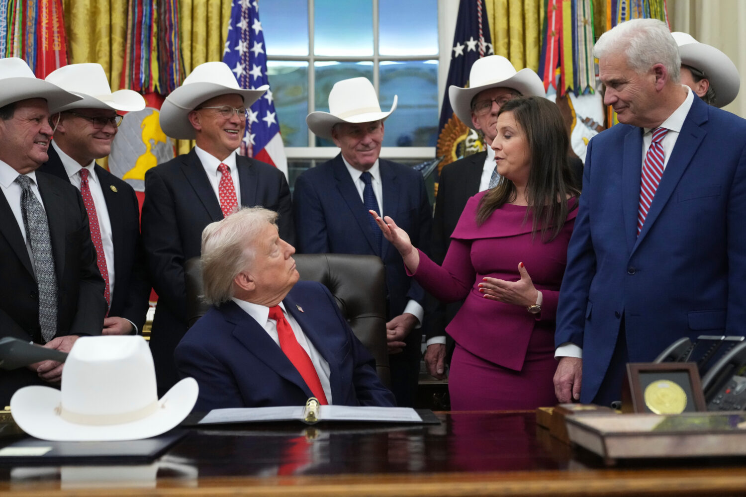 President Donald Trump talks to Rep. Elise Stefanik, R-N.Y., second from right, while Rep. Tom Emme...