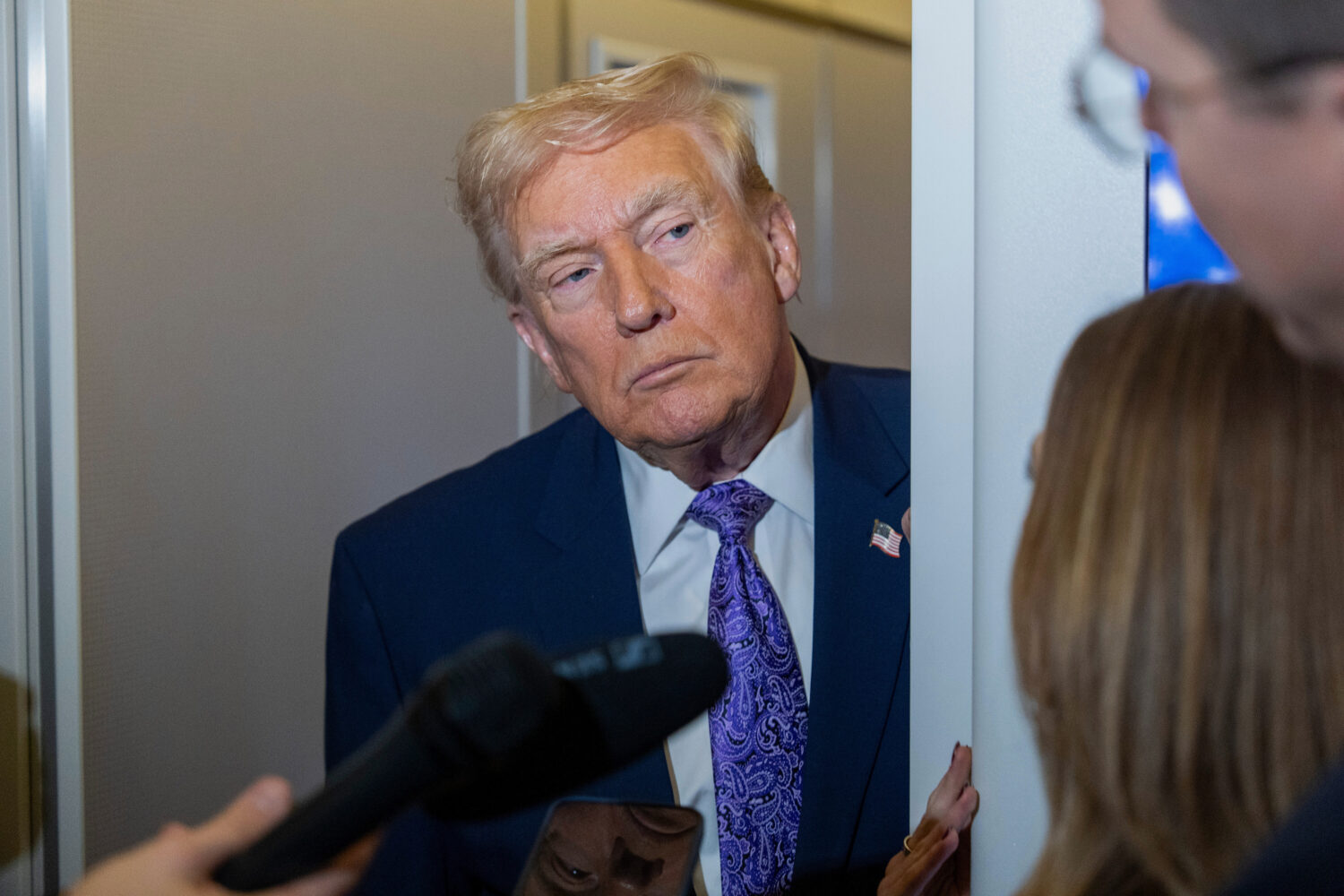 President Donald Trump speaks with reporters while in flight on Air Force One from his Mar-a-Lago e...