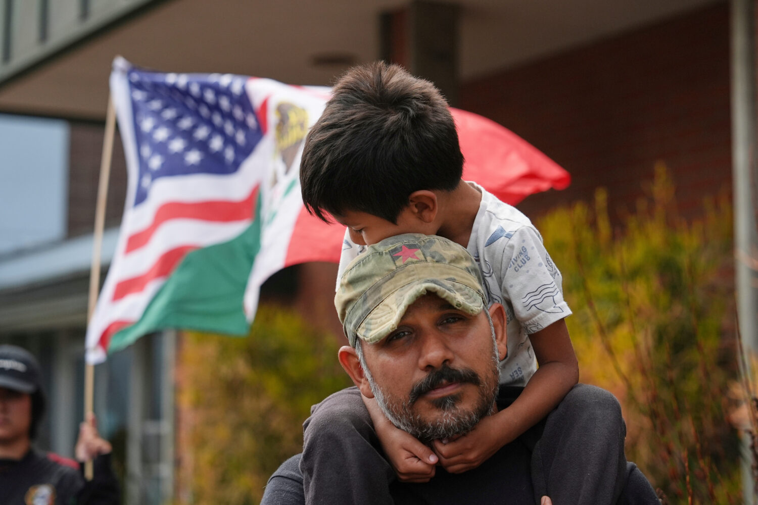 FILE - Gerardo Santos lifts his son Xavier, 5, on his shoulders during a protest in reaction to imm...