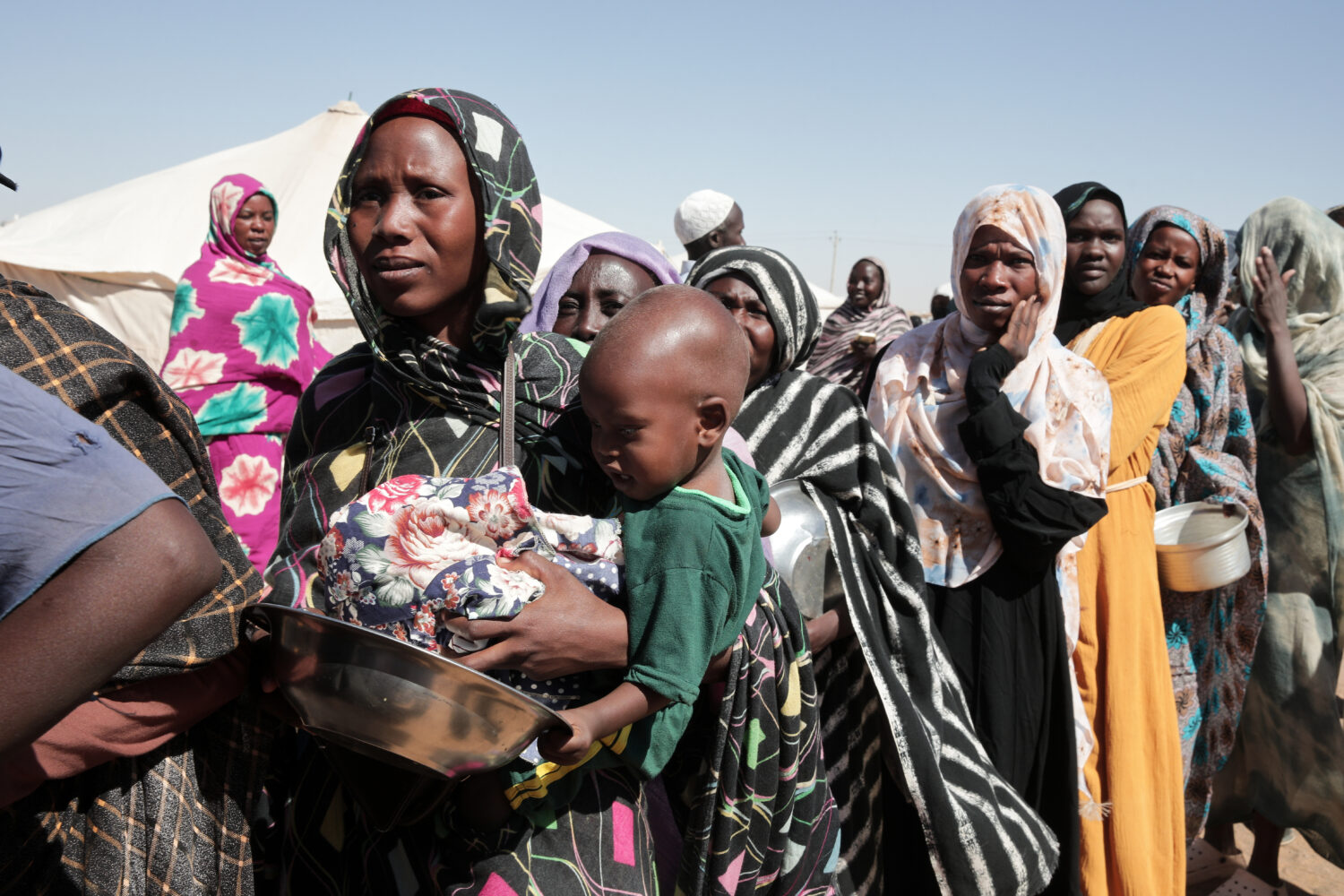 FILE - Women displaced from El-Fasher stand in line to receive food aid at the newly established El...