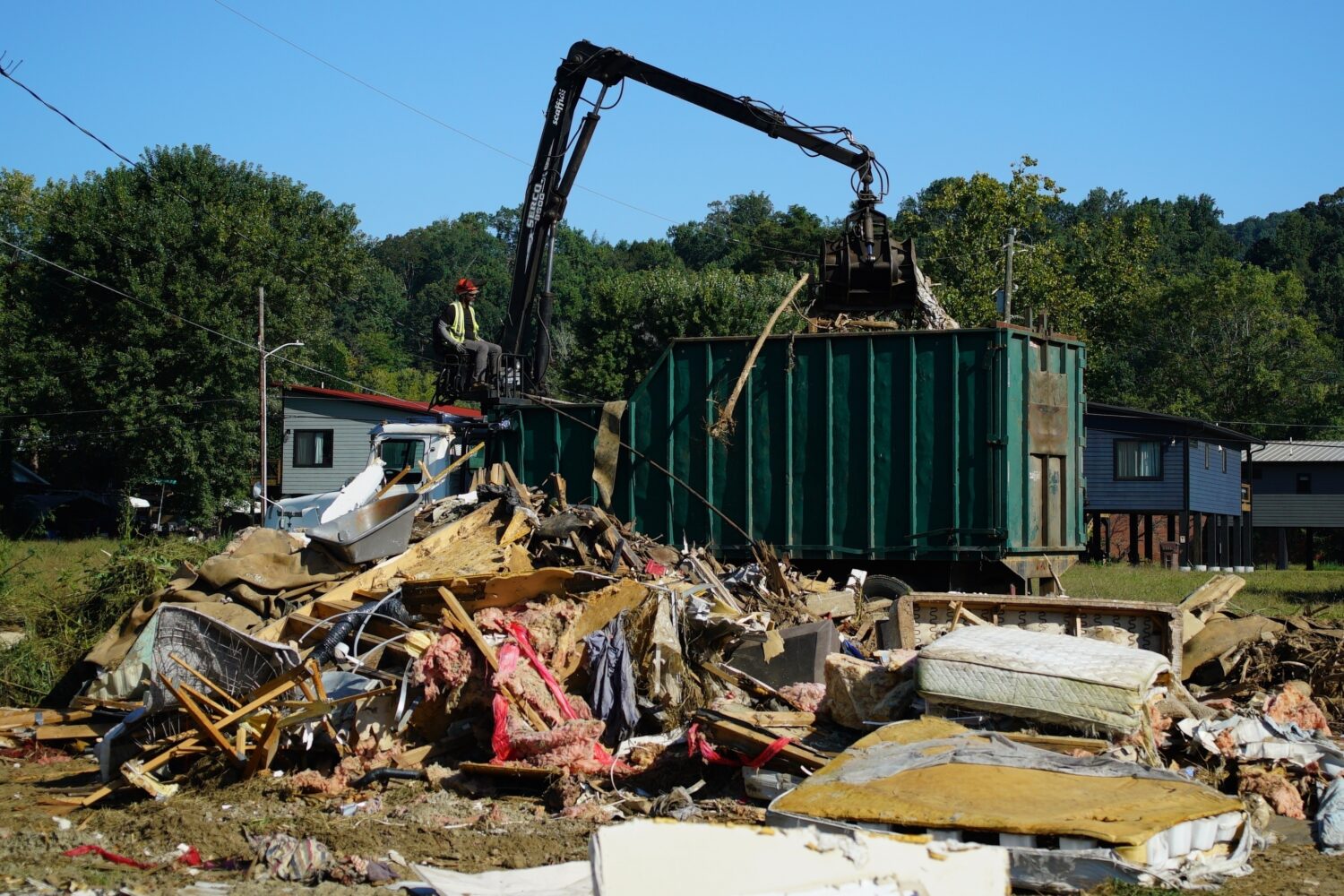 FILE -A claw operator scoops up debris from homes demolished following Hurricane Helene in Old Fort...