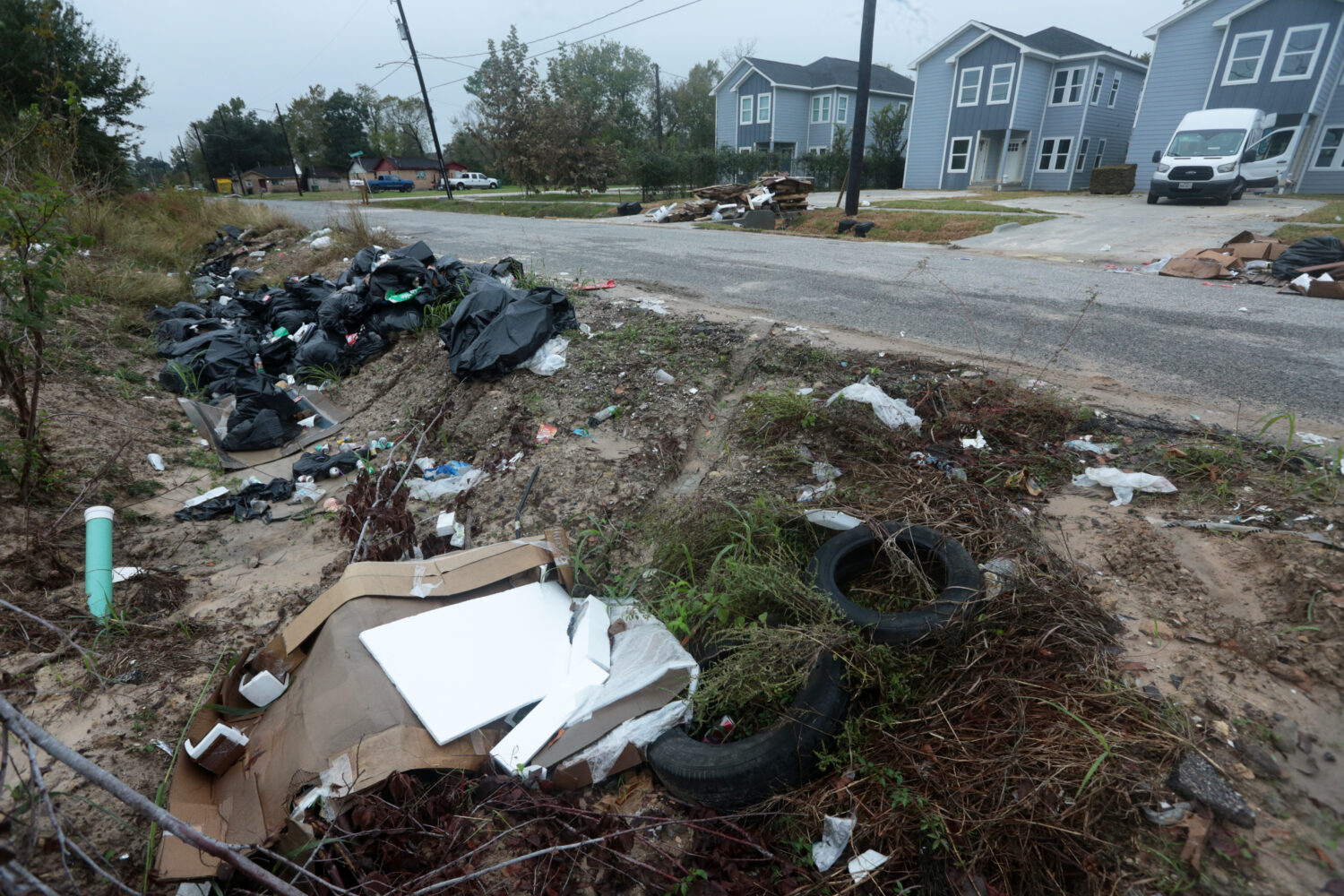 Piles of trash fill the ditch across a construction site in the Trinity Gardens neighborhood in nor...