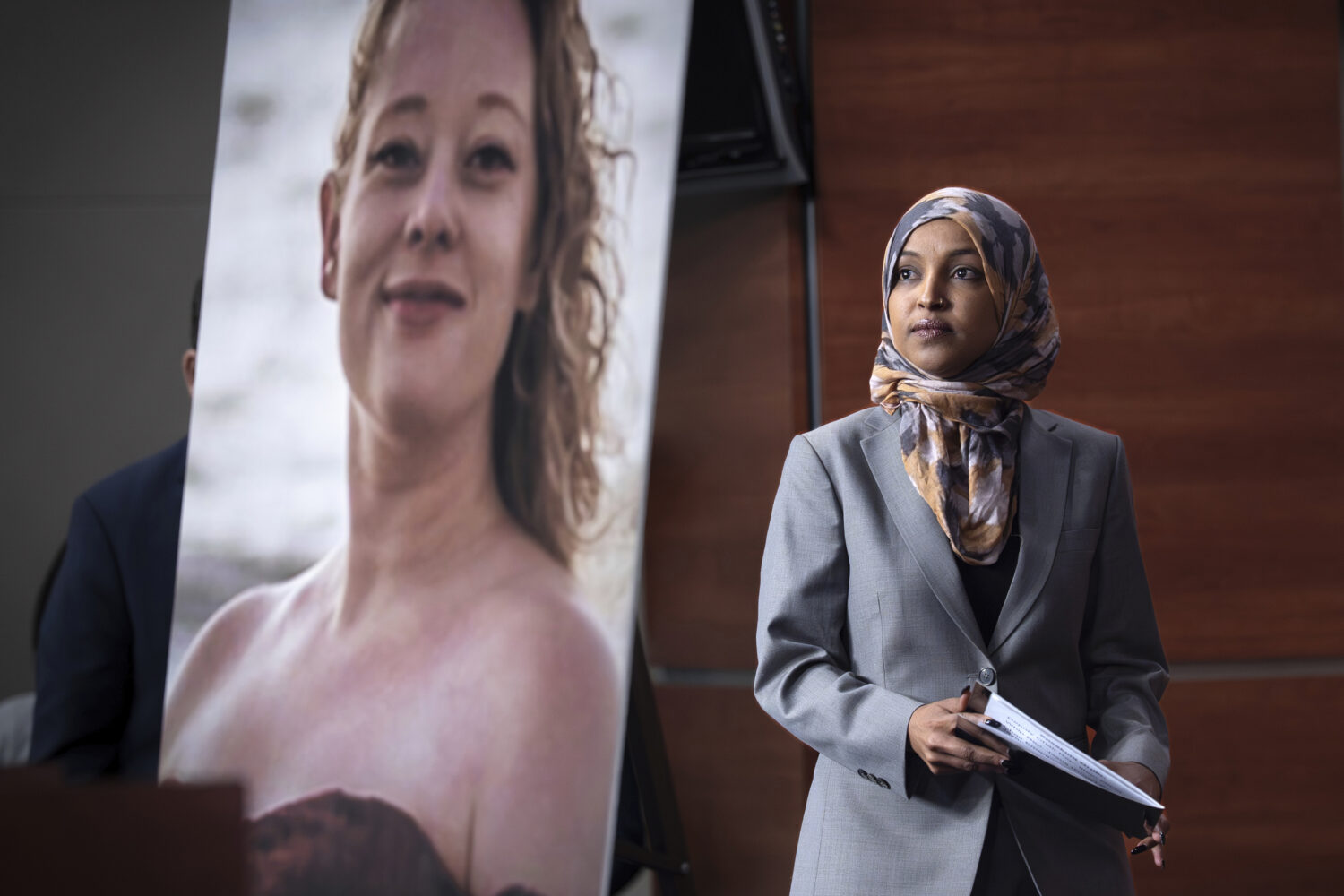 Rep. Ilhan Omar, D-Minn., walks beside a photograph of Renee Good, the woman shot and killed in her...