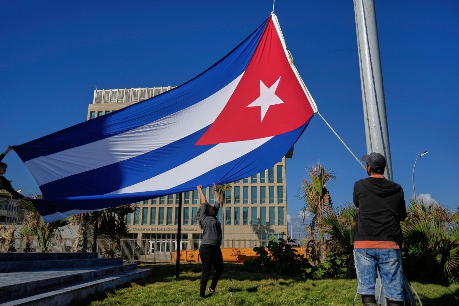 Workers fly the Cuban flag at half-mast at the Anti-Imperialist Tribune near the U.S. embassy in Ha...