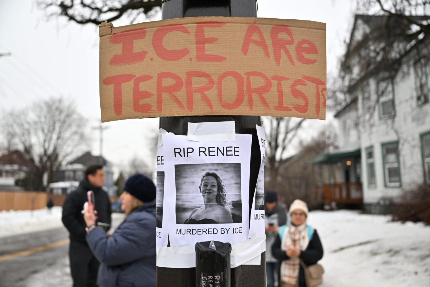 People gather around a makeshift memorial honoring the victim of a fatal shooting involving federal...