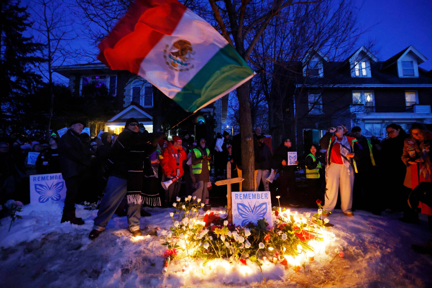 People gather for a vigil after an Immigration and Customs Enforcement officer shot and killed a wo...