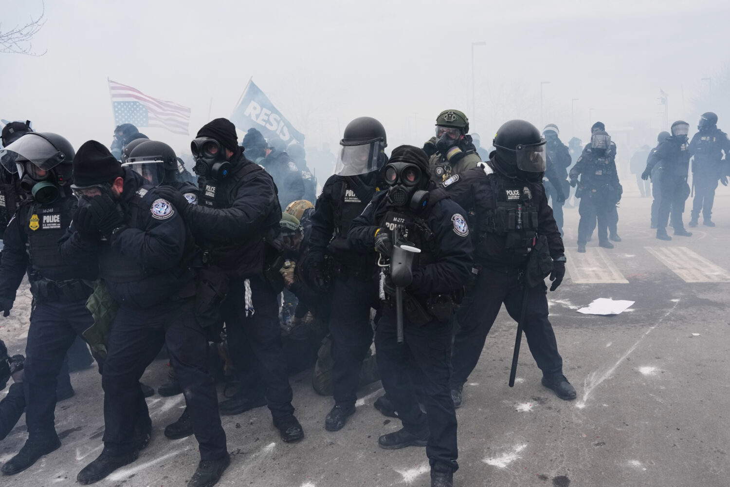 Federal immigration officers confront protesters outside Bishop Henry Whipple Federal Building, Thu...