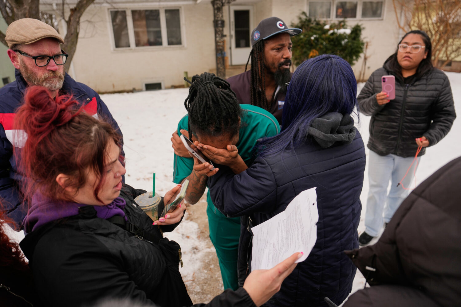 A family member, center, reacts after federal immigration officers make an arrest Sunday, Jan. 11, ...