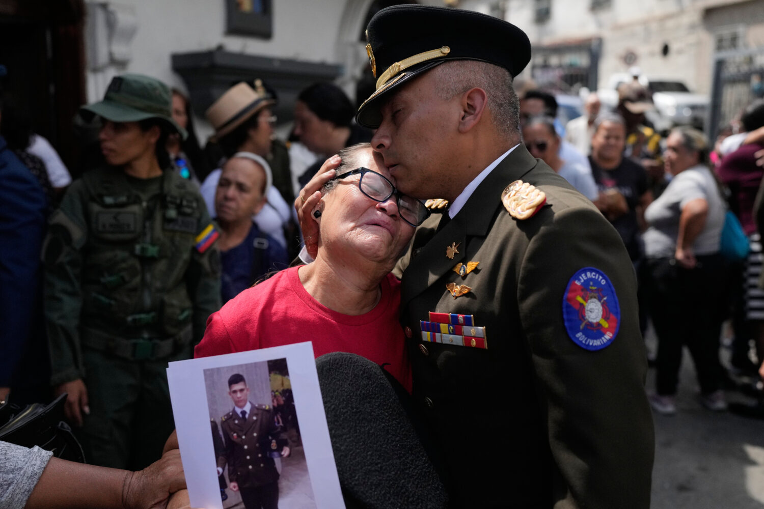 A military officer comforts Ramona Palma, the mother of Venezuelan soldier Cesar Garcia, who was ki...
