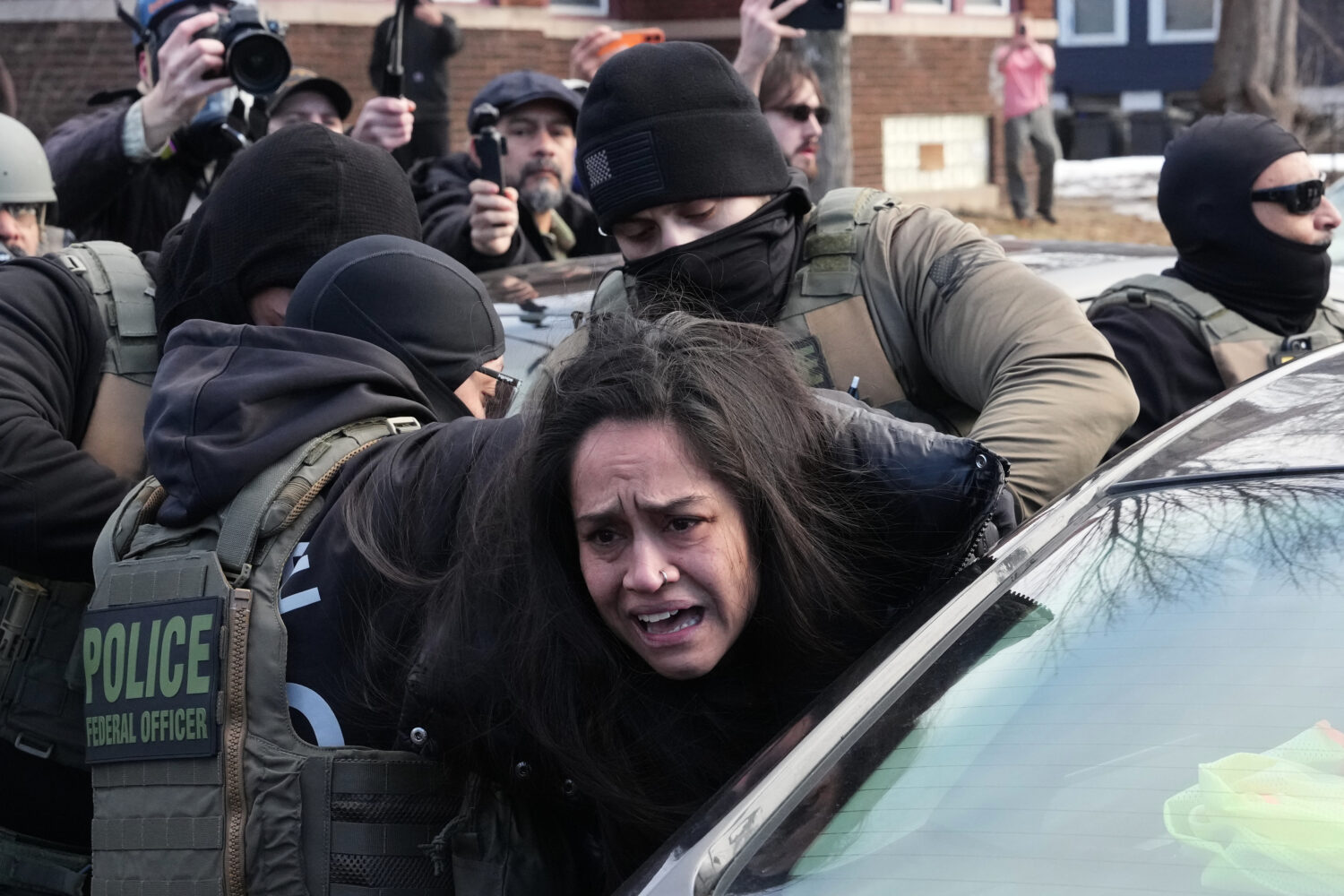 A person is detained by federal agents near the scene where Renee Good was fatally shot by an ICE o...