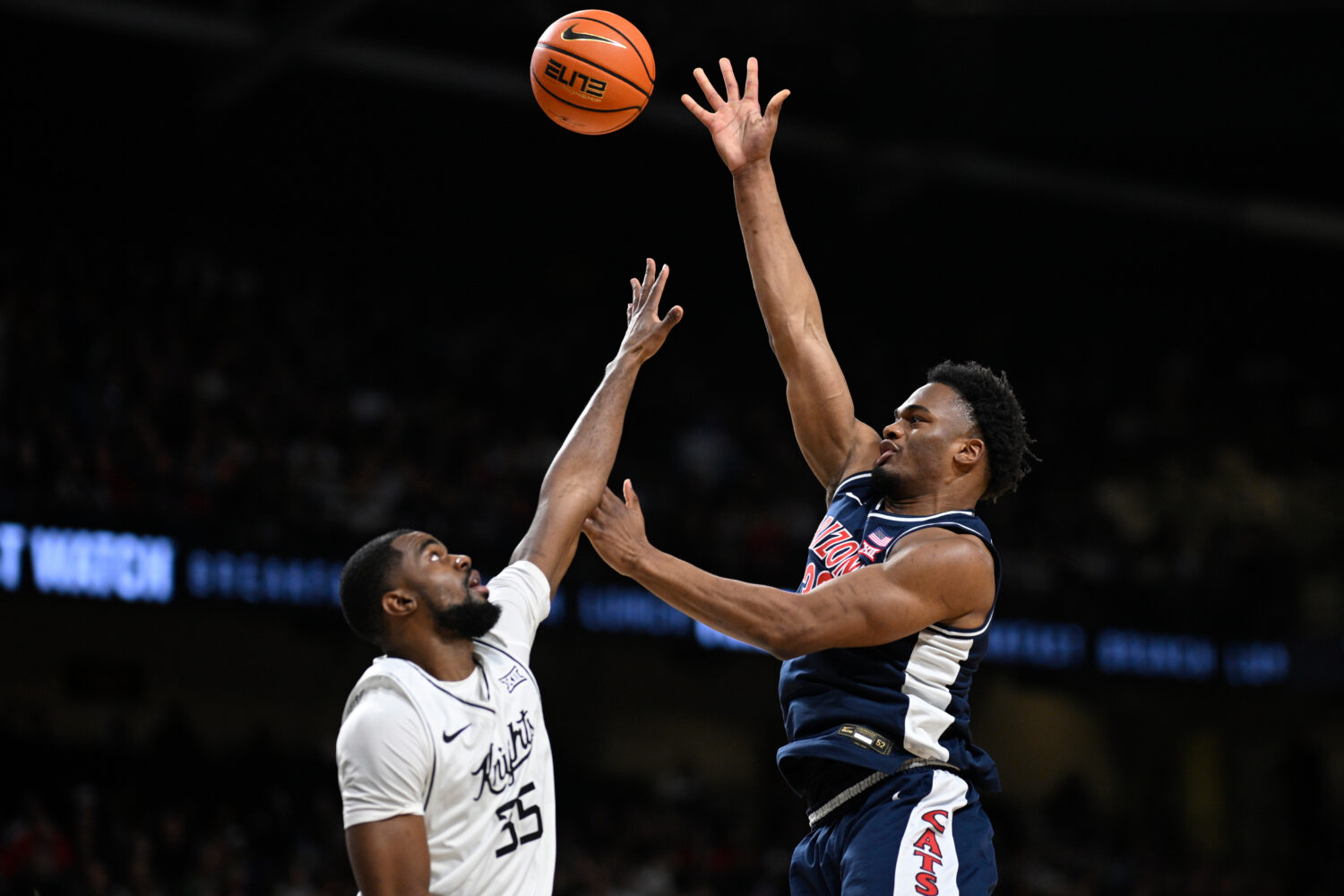 Arizona forward Tobe Awaka, right, shoots as Central Florida forward Devan Cambridge (35) defends d...