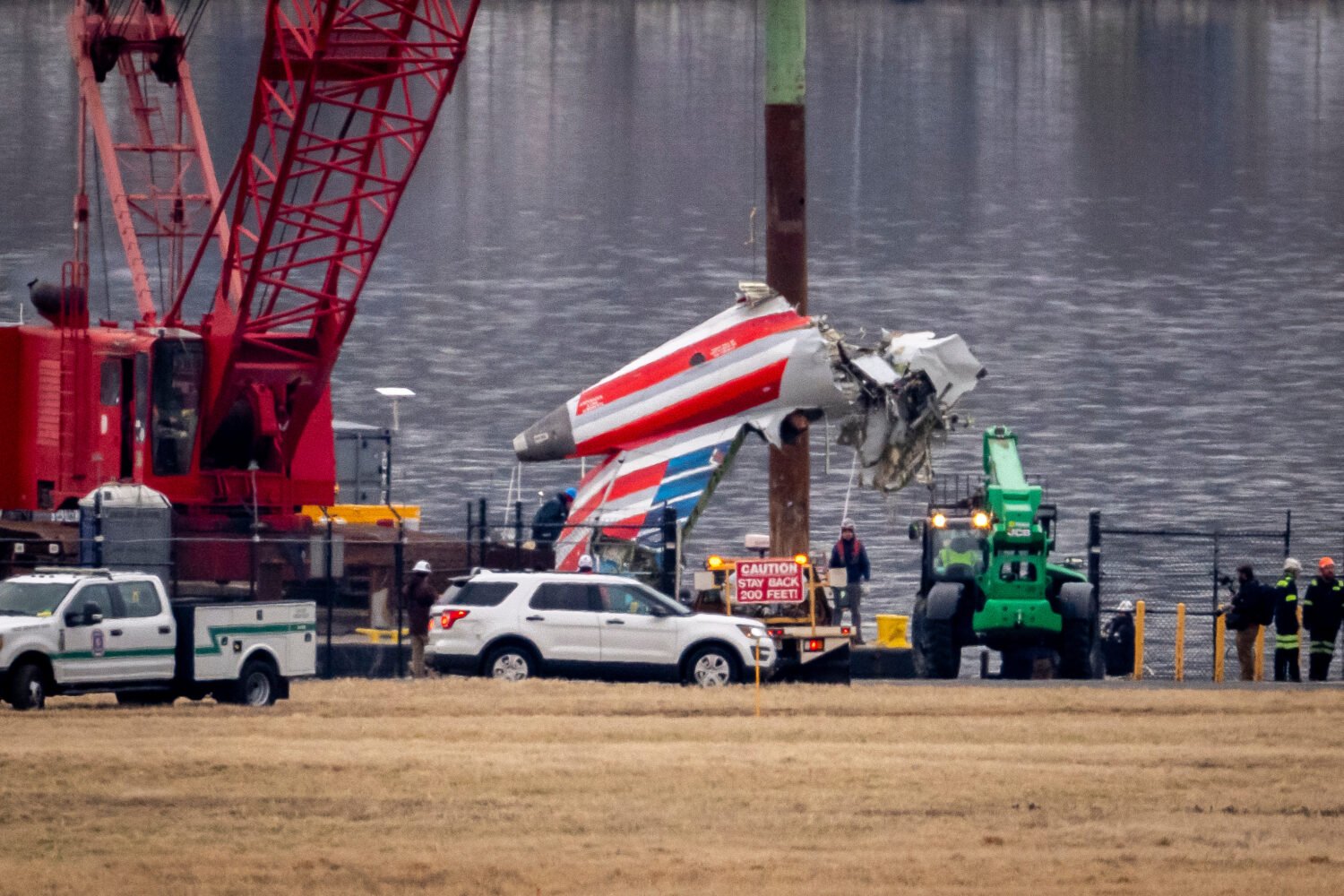 FILE - A crane offloads a piece of wreckage from a salvage vessel onto a flatbed truck, near the wr...