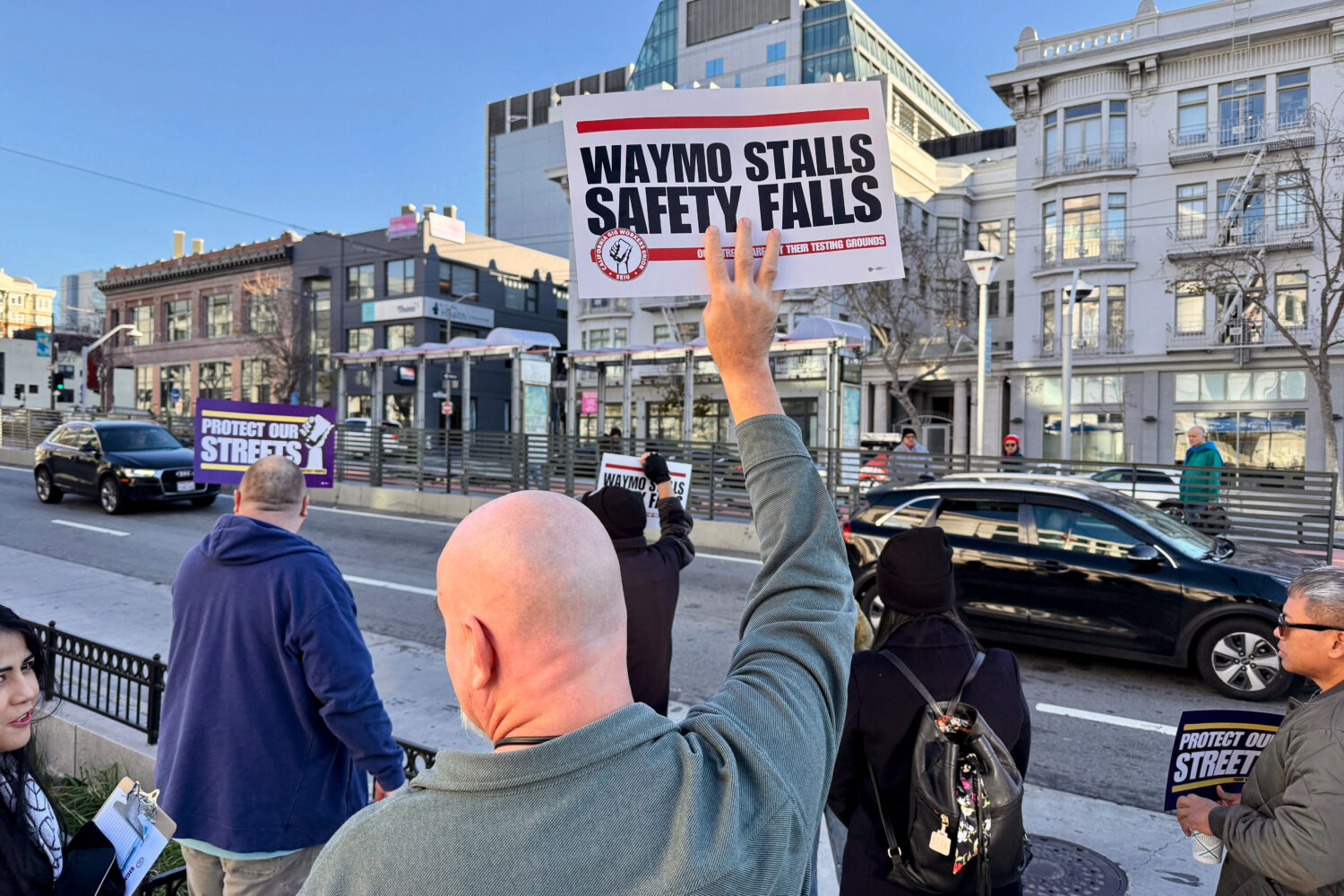 Demonstrators holds signs during a protest by Uber and Lyft drivers asking state regulators to take...