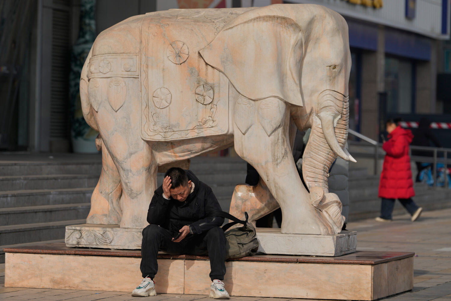 A man reacts while holding his smartphone in Beijing, China, Thursday, Jan. 15, 2026. (AP Photo/Ng ...