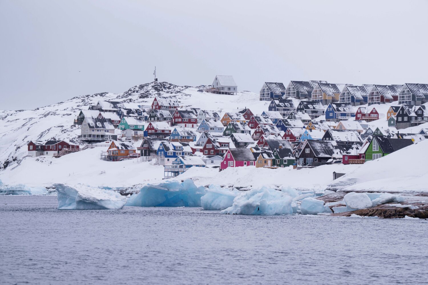 FILE - Coloured houses covered by snow are seen from the sea in Nuuk, Greenland, on March 6, 2025. ...
