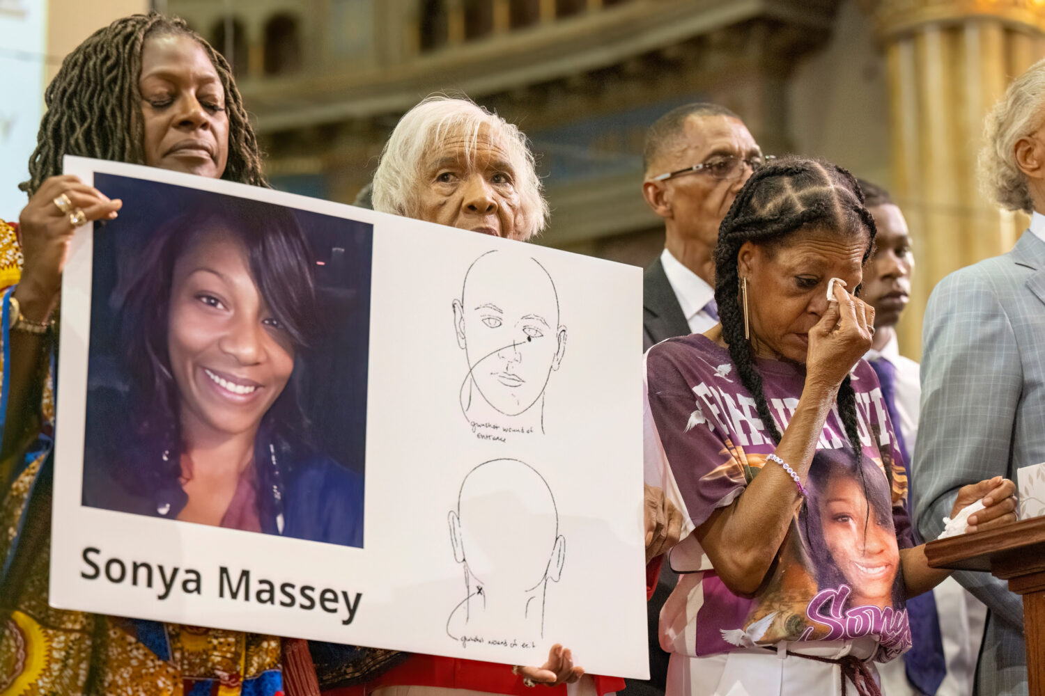 FILE - Donna Massey, center right, wipes tears from her face as she listens to Rev. Al Sharpton, ri...