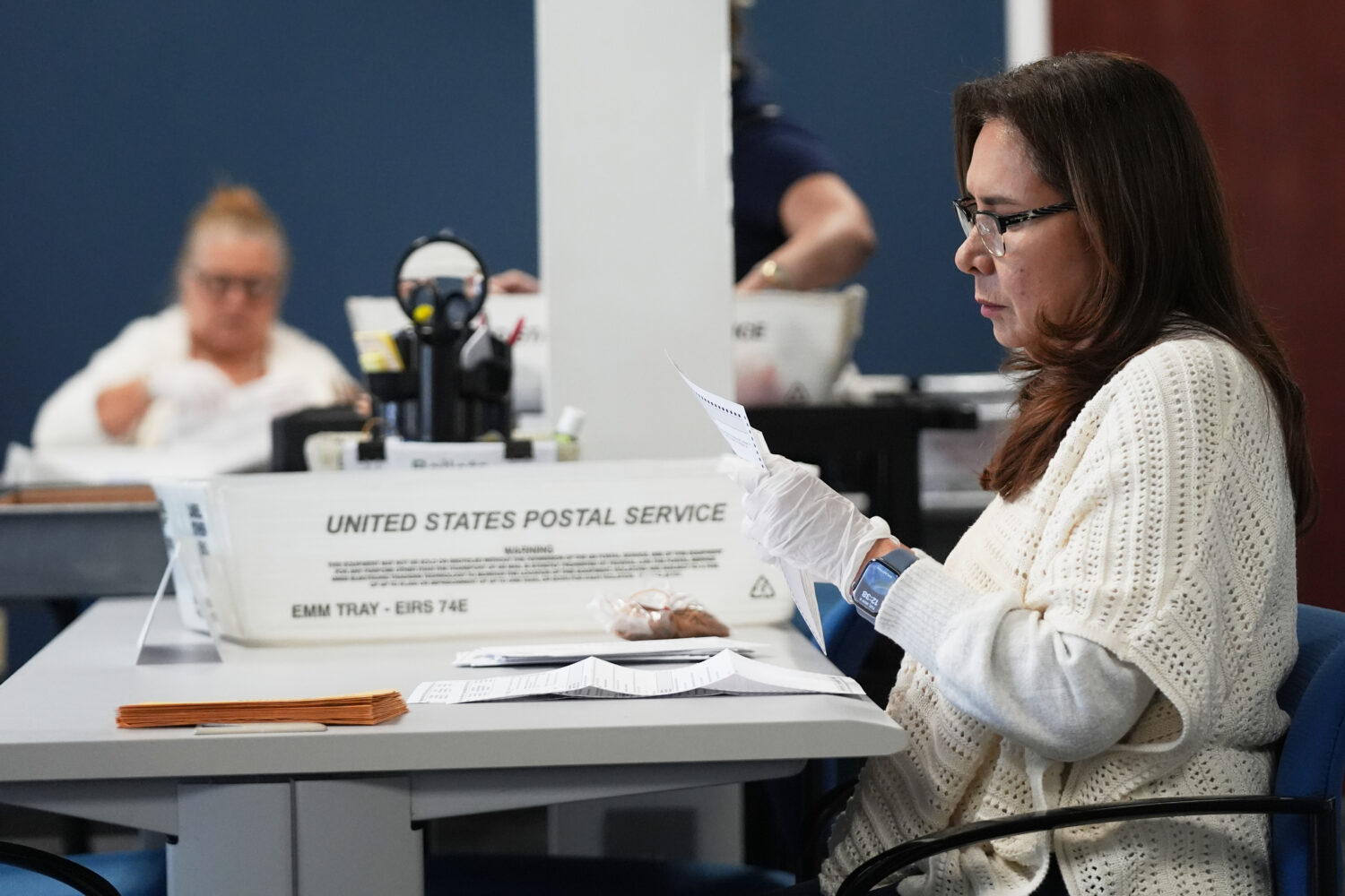 FILE - Employees sort vote-by-mail ballots from municipal elections on Election Day at the Miami-Da...