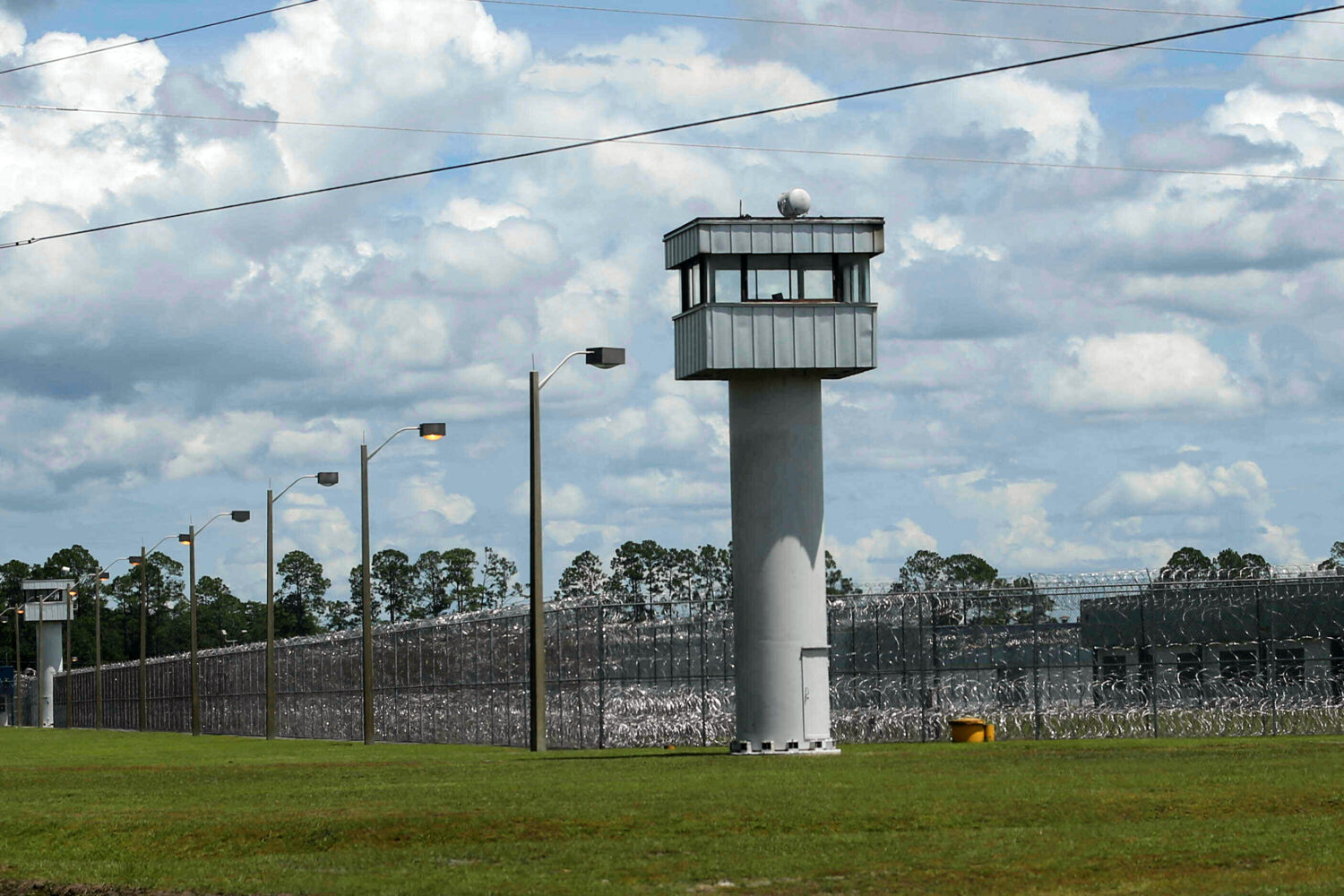 FILE - Fence and towers at the Baker Correctional Institution, Sanderson, Fla., Thursday, Aug. 14, ...