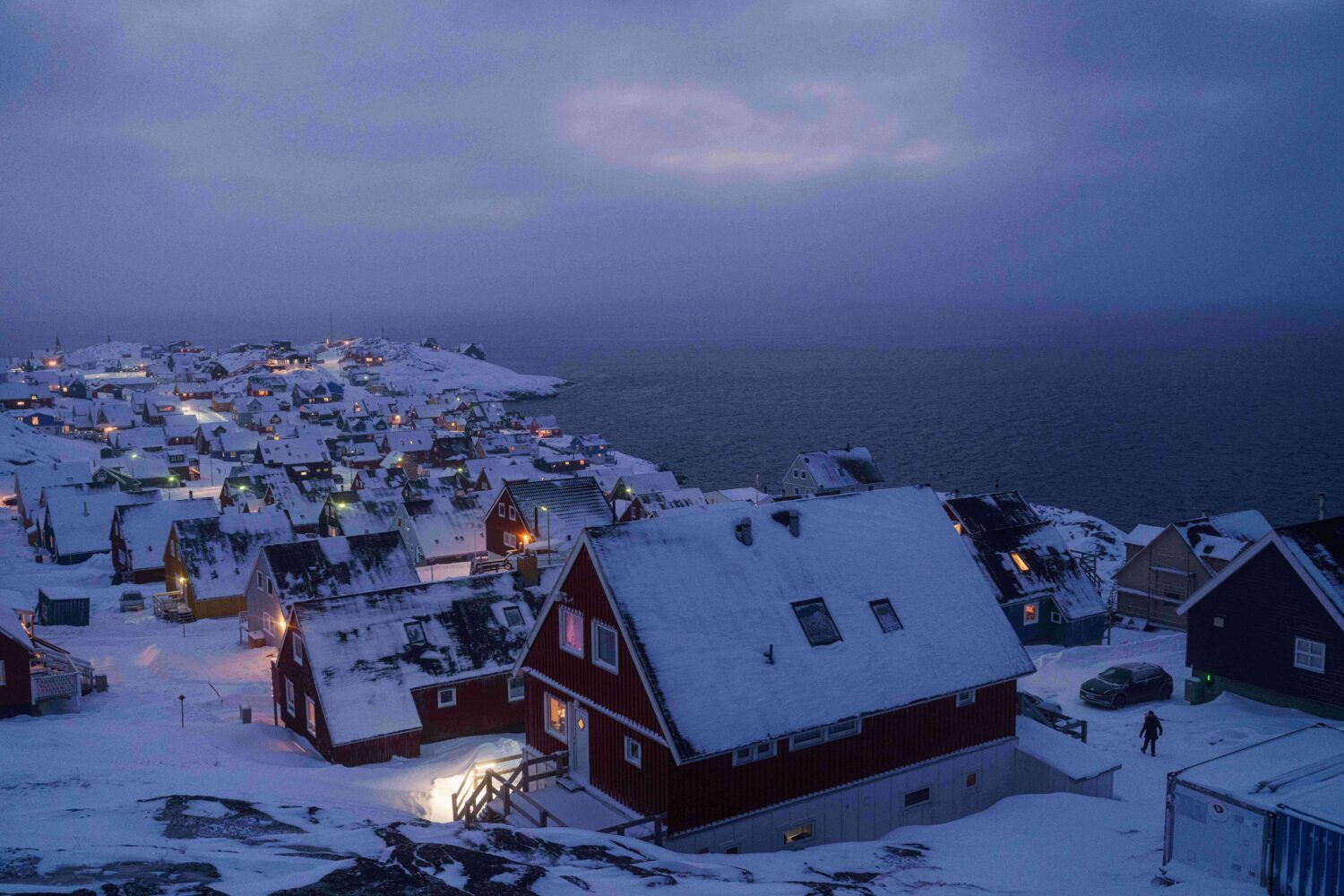 Houses covered by snow are seen on the coast of a sea inlet of Nuuk, Greenland, on Monday, Jan. 12,...