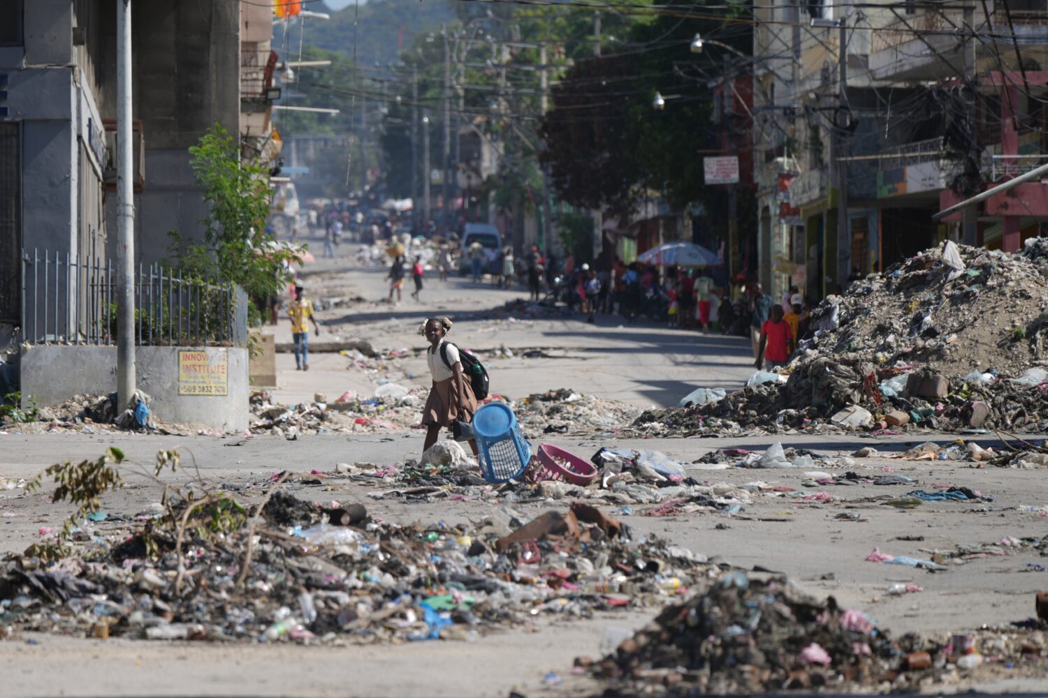 A youth crosses a street littered with garbage in downtown in Port-au-Prince, Haiti, Tuesday, Jan. ...