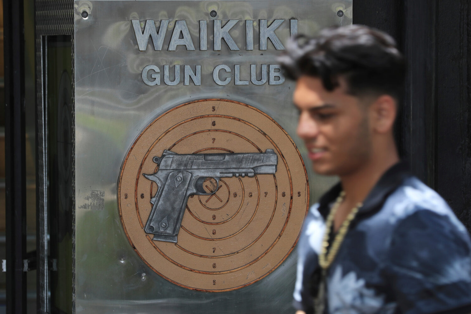 FILE - A pedestrian walks past the Waikiki Gun Club in Honolulu, Thursday, June, 23, 2022. (AP Phot...