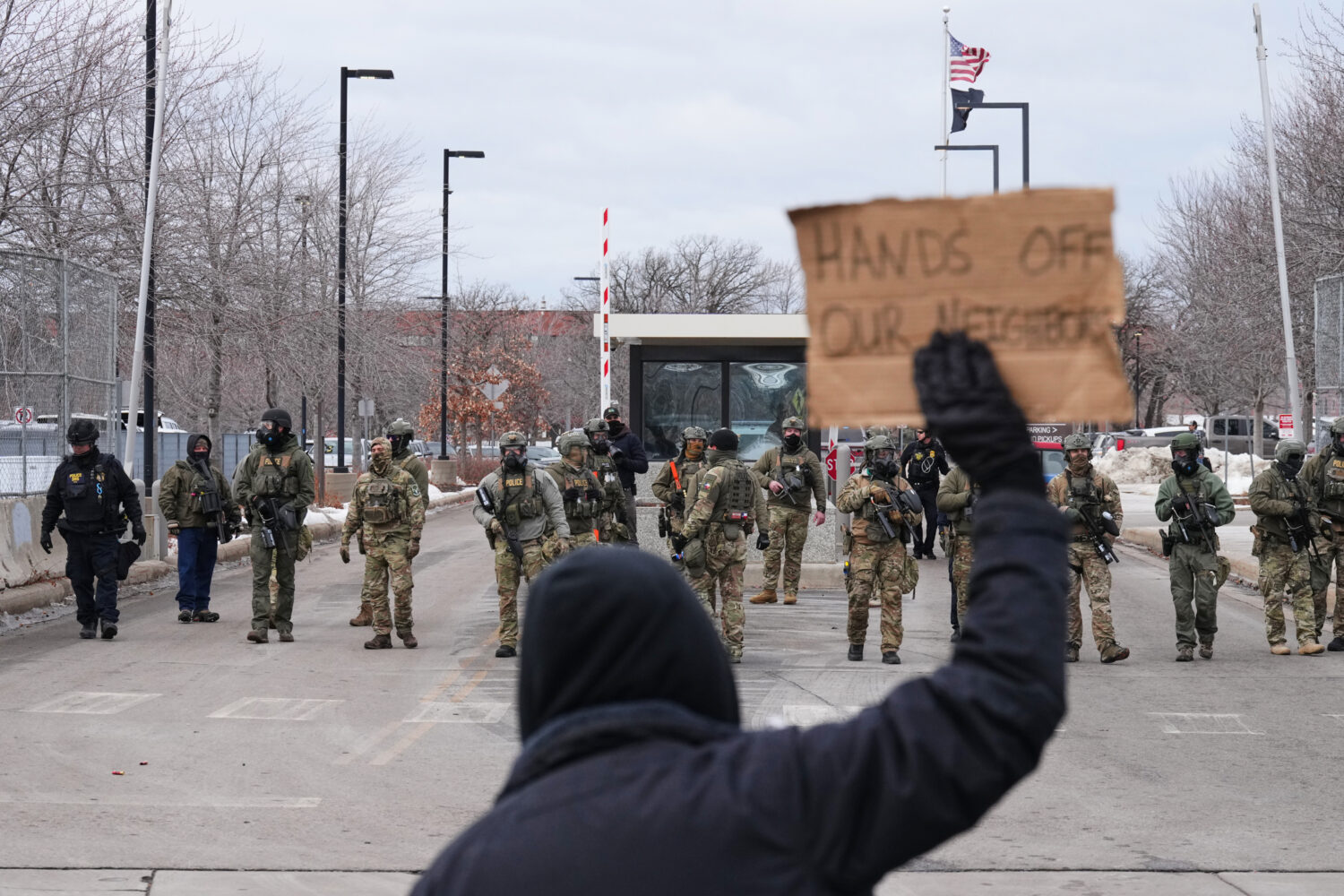 Protesters confront federal immigration officers outside the Bishop Henry Whipple Federal Building,...