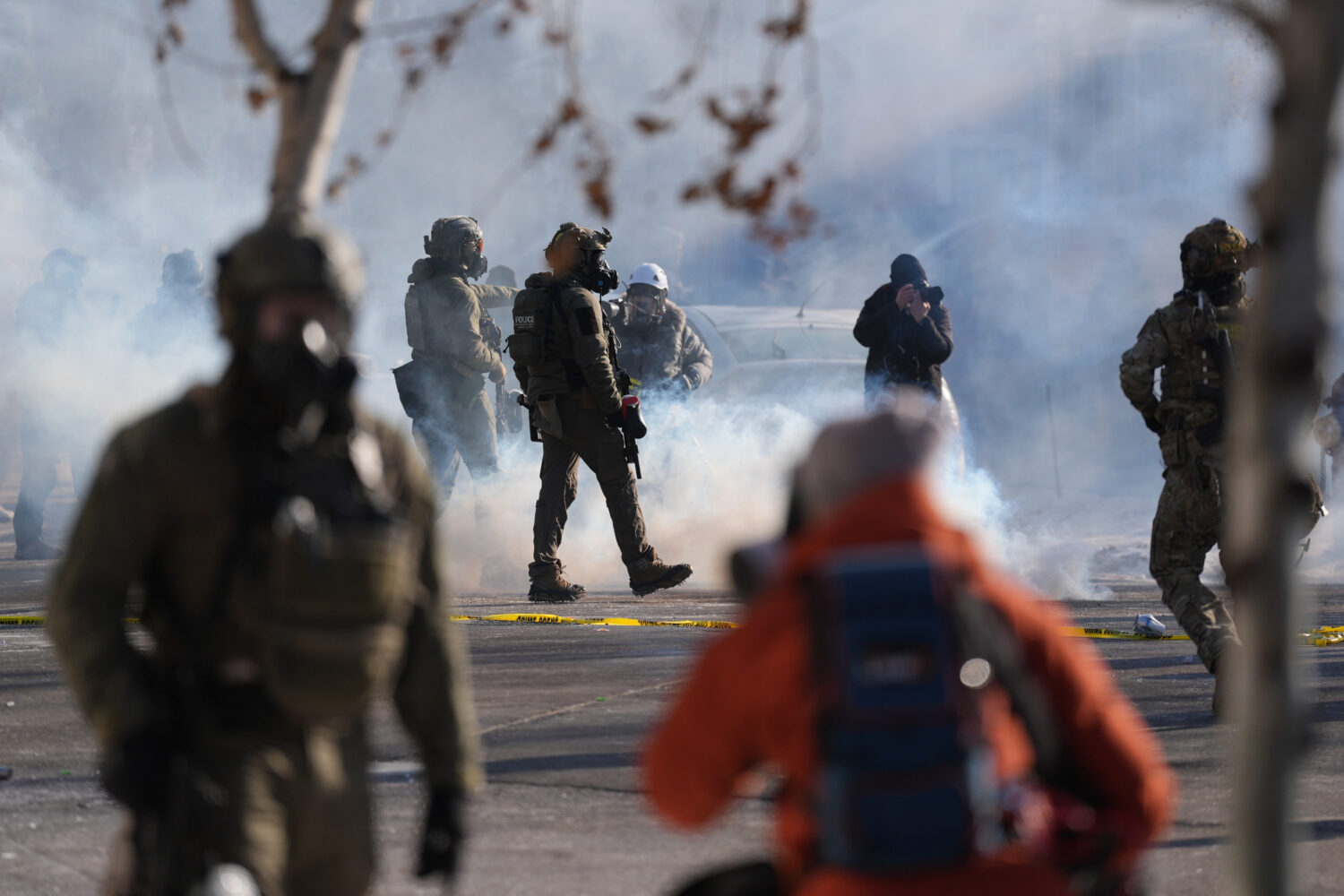 Federal immigration officers deploy tear gas at observers after a shooting Saturday, Jan. 24, 2026,...