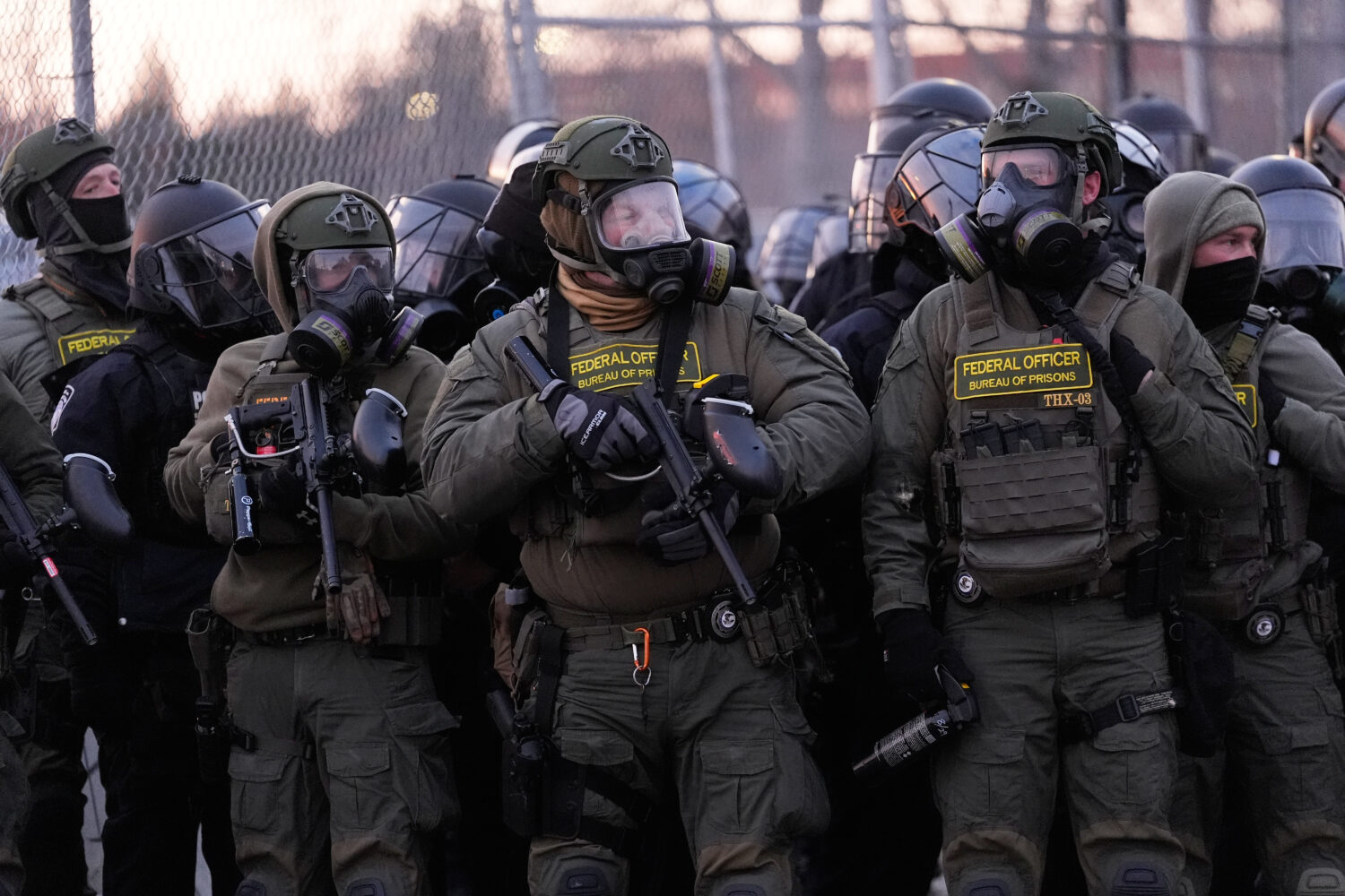 Federal officers stand outside the Bishop Henry Whipple Federal Building during a protest on Saturd...