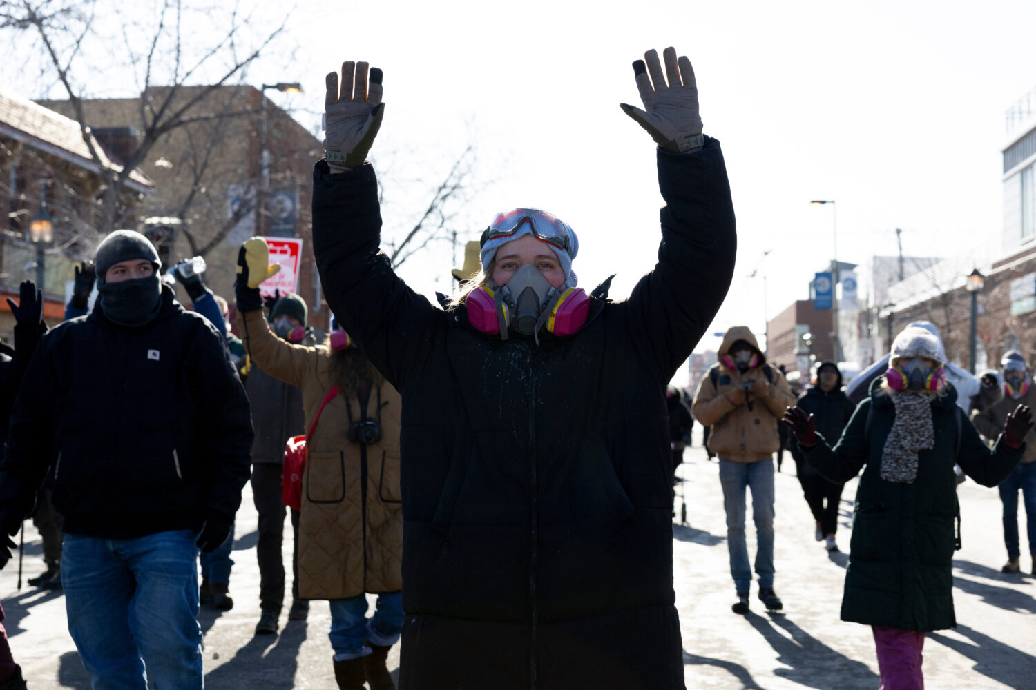 Protesters advance toward federal agents with their hands up near the site of the fatal shooting of...