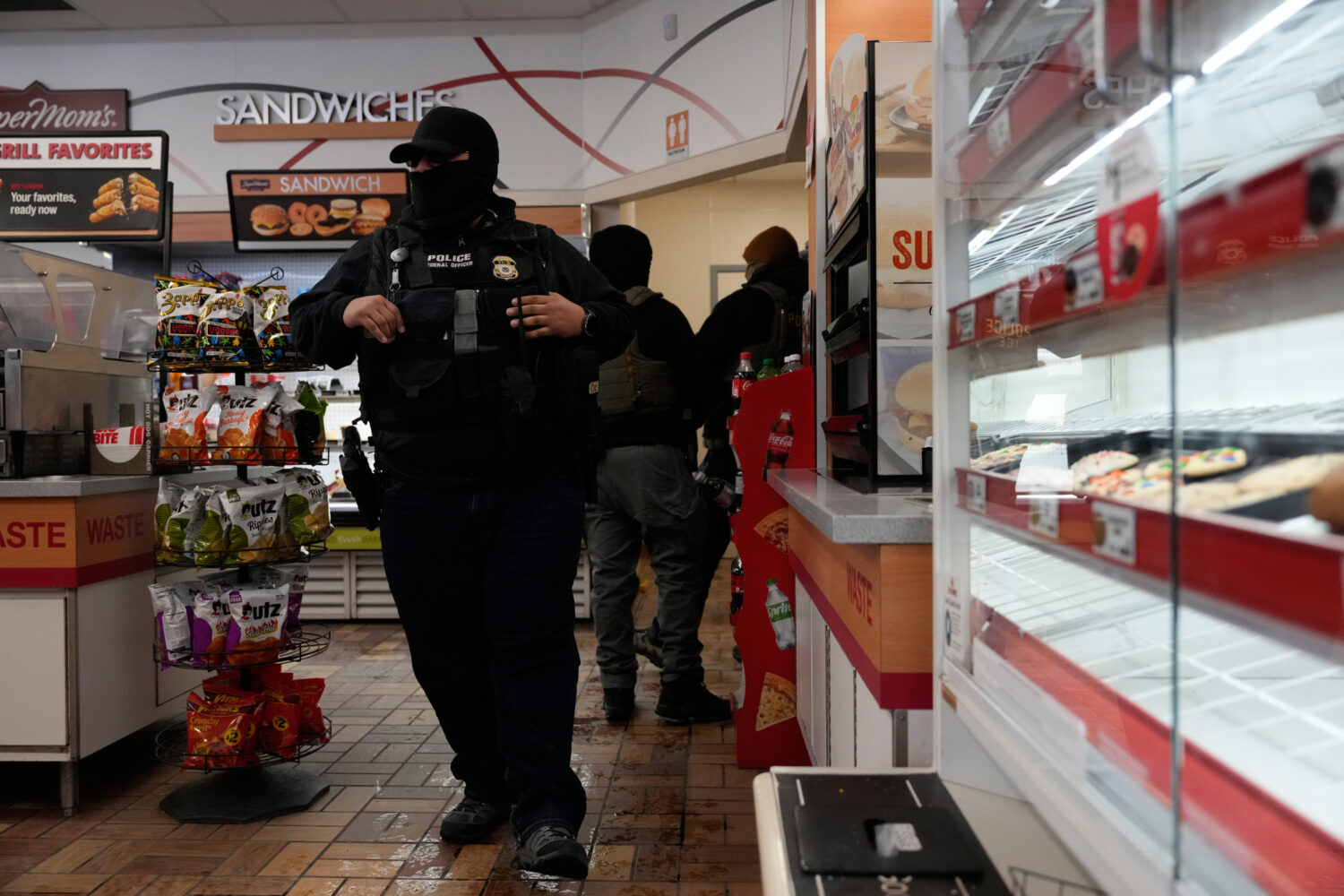 ICE agents make use of the facilities at a gas station, Monday, Jan. 19, 2026, in St. Paul, Minn. (...