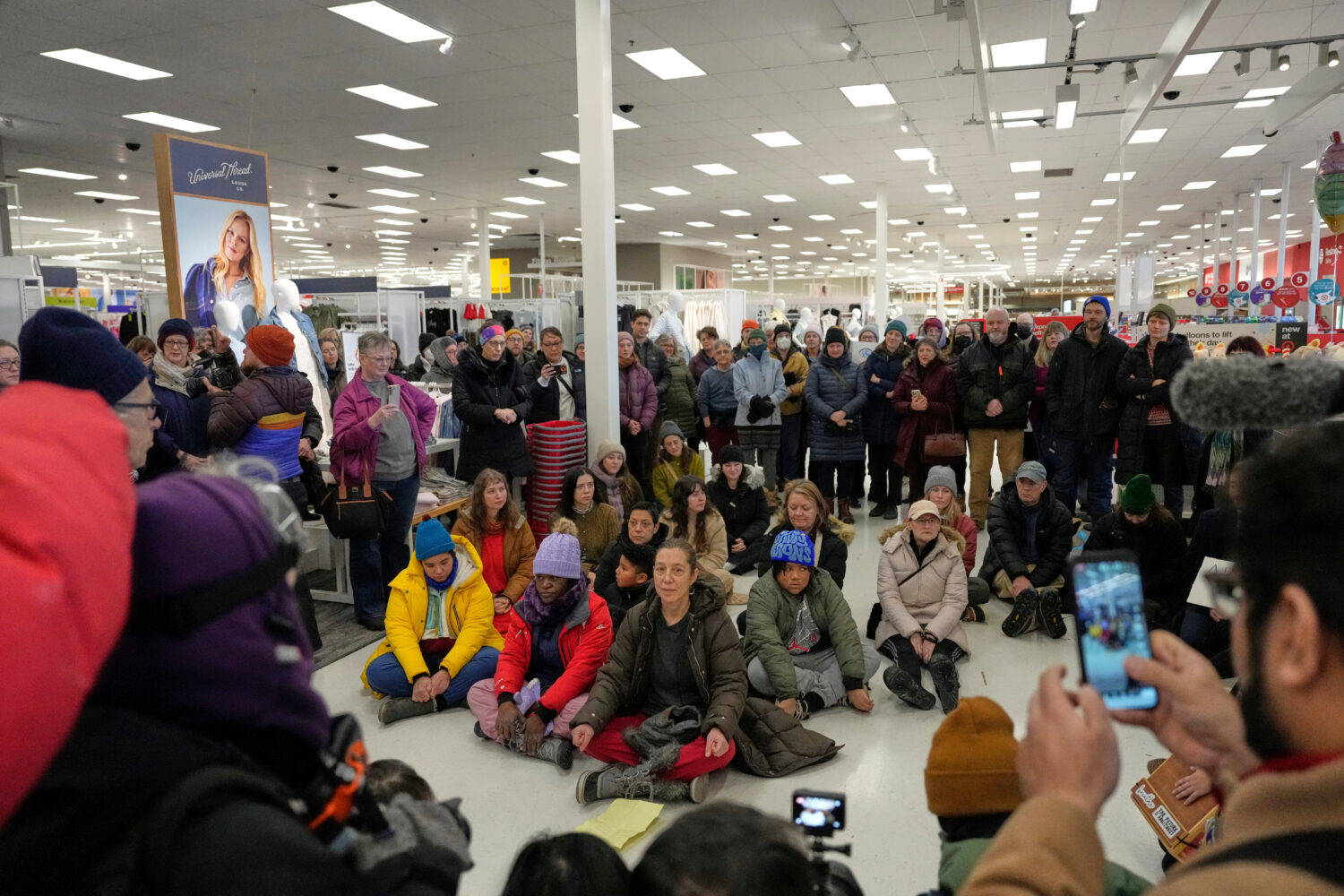 Community members and neighbors of people detained by ICE gather in protest at a Target store, Mond...