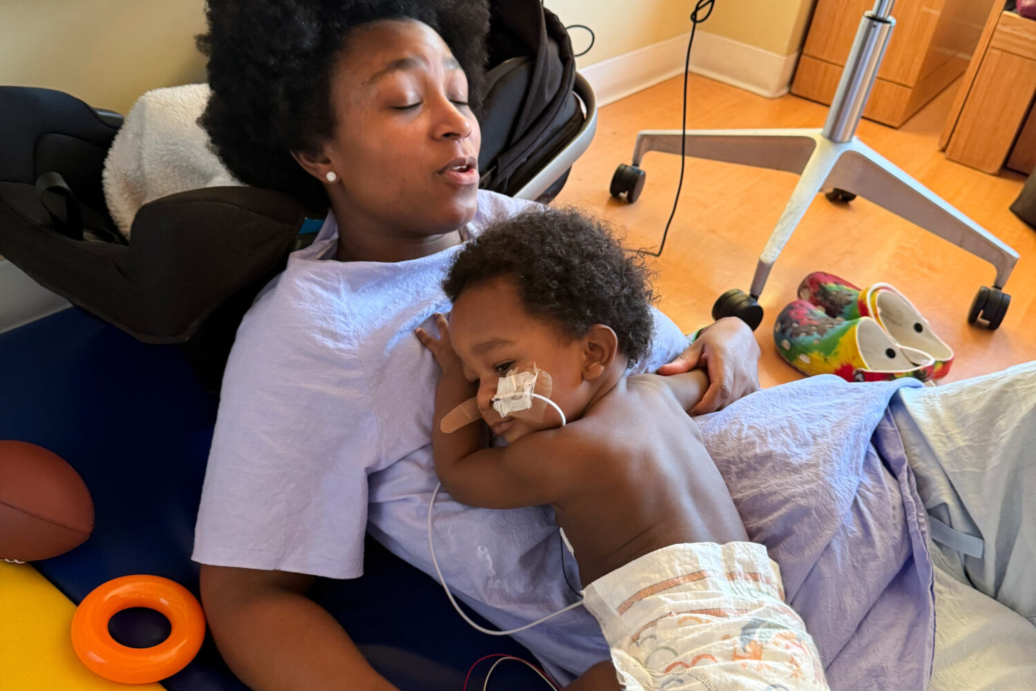 In this photo provided by the family, Ashaan Carter lies on his mother, Angel Carter, at a children...