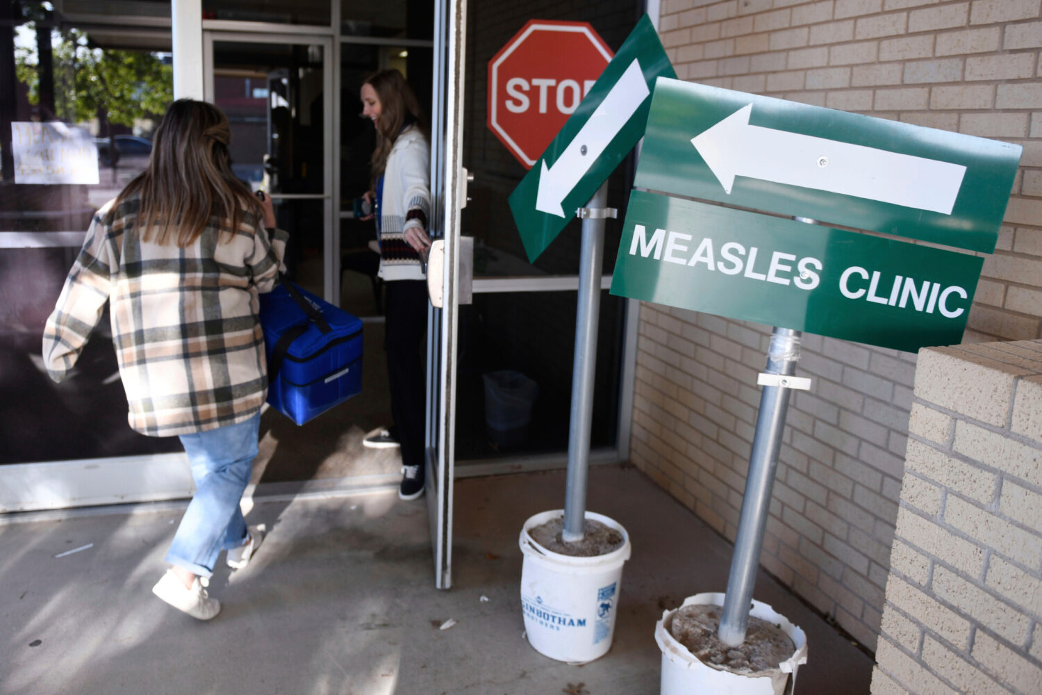 FILE - Health department staff members enter the Andrews County Health Department measles clinic ca...