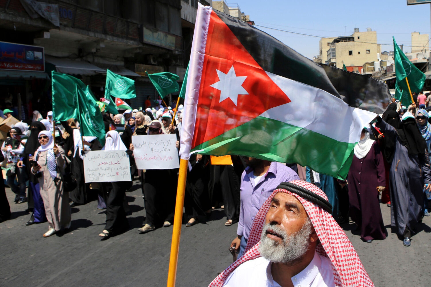 FILE -- A Jordanian protester carries the national flag during a rally by the Muslim Brotherhood, i...