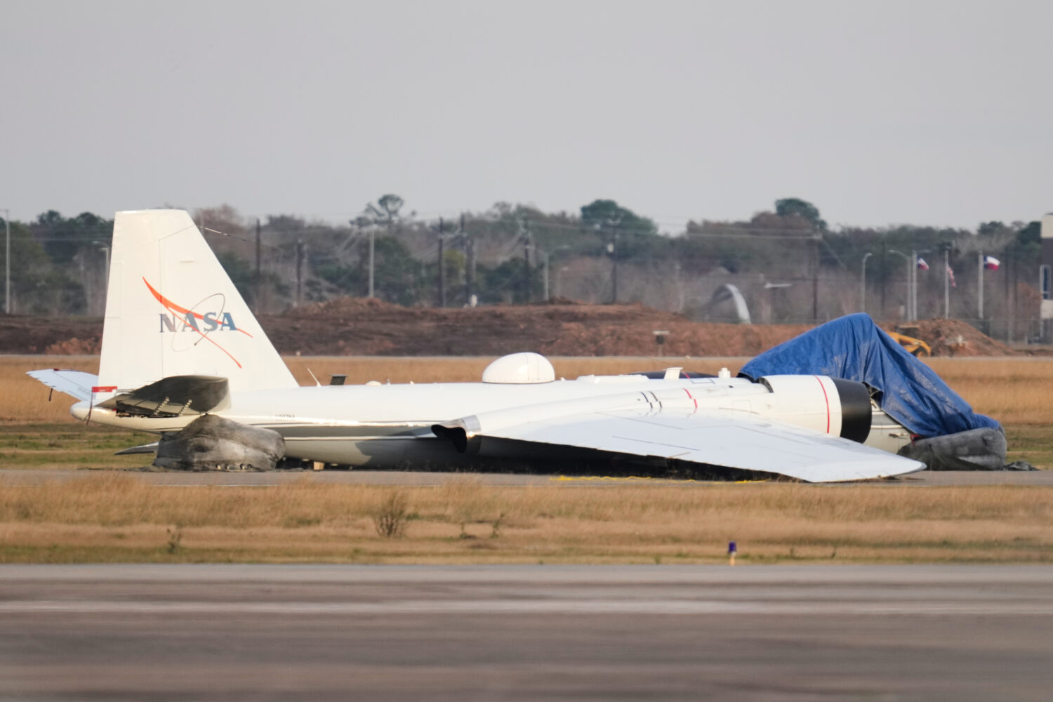 A NASA aircraft sits near a runway at Ellington Airport after making a belly landing on Tuesday, Ja...