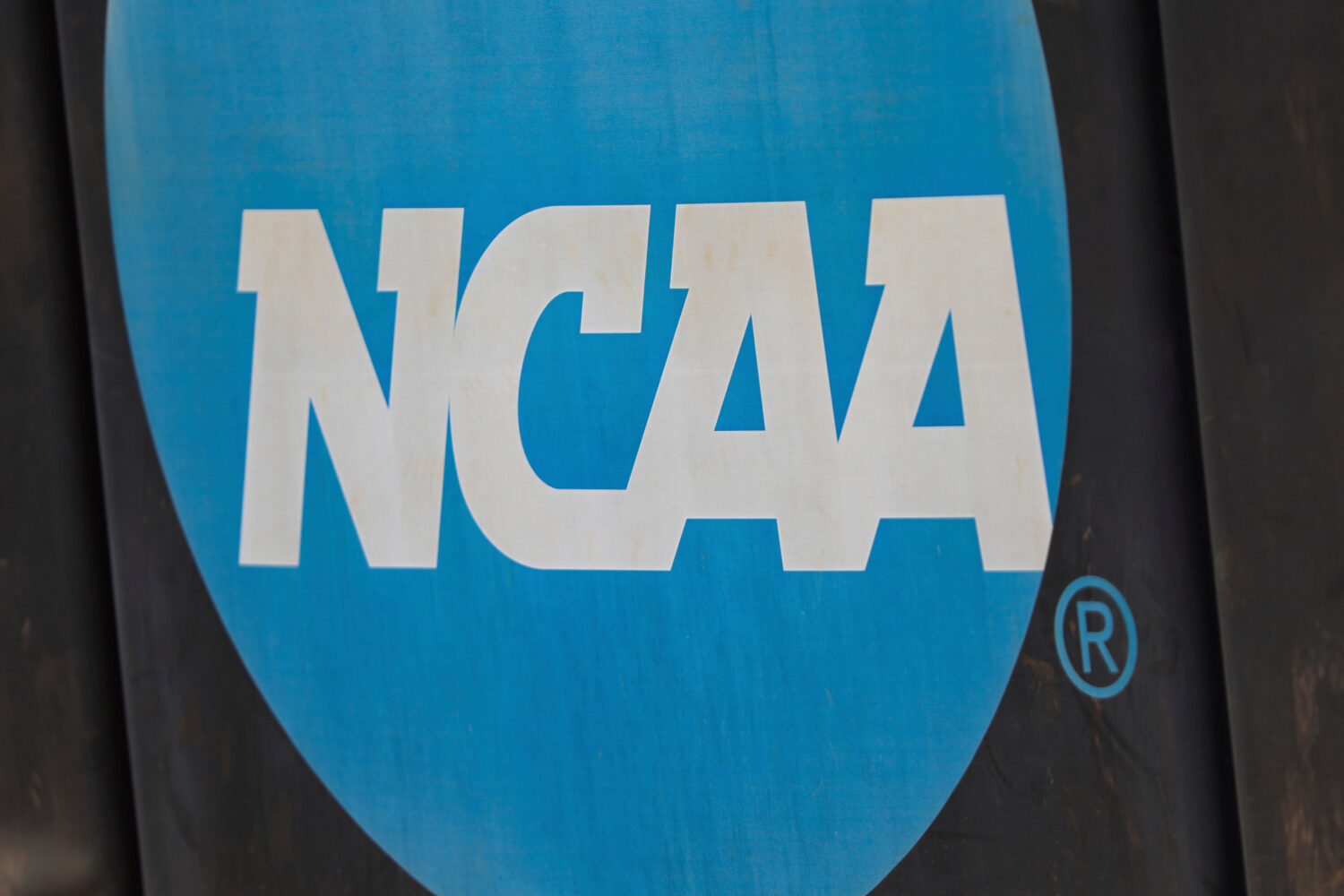 FILE - NCAA logo displayed on the fence before an NCAA softball game between Jacksonville and FGCU,...