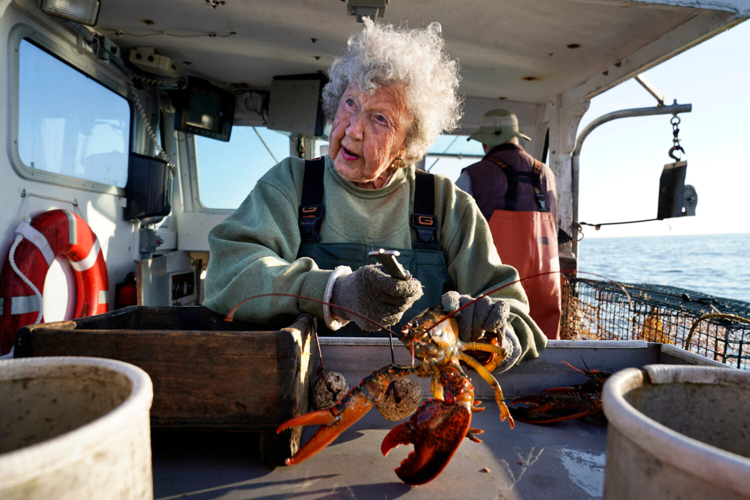 FILE - Virginia Oliver, 101, works as a sternman, measuring and banding lobsters on the boat of her...
